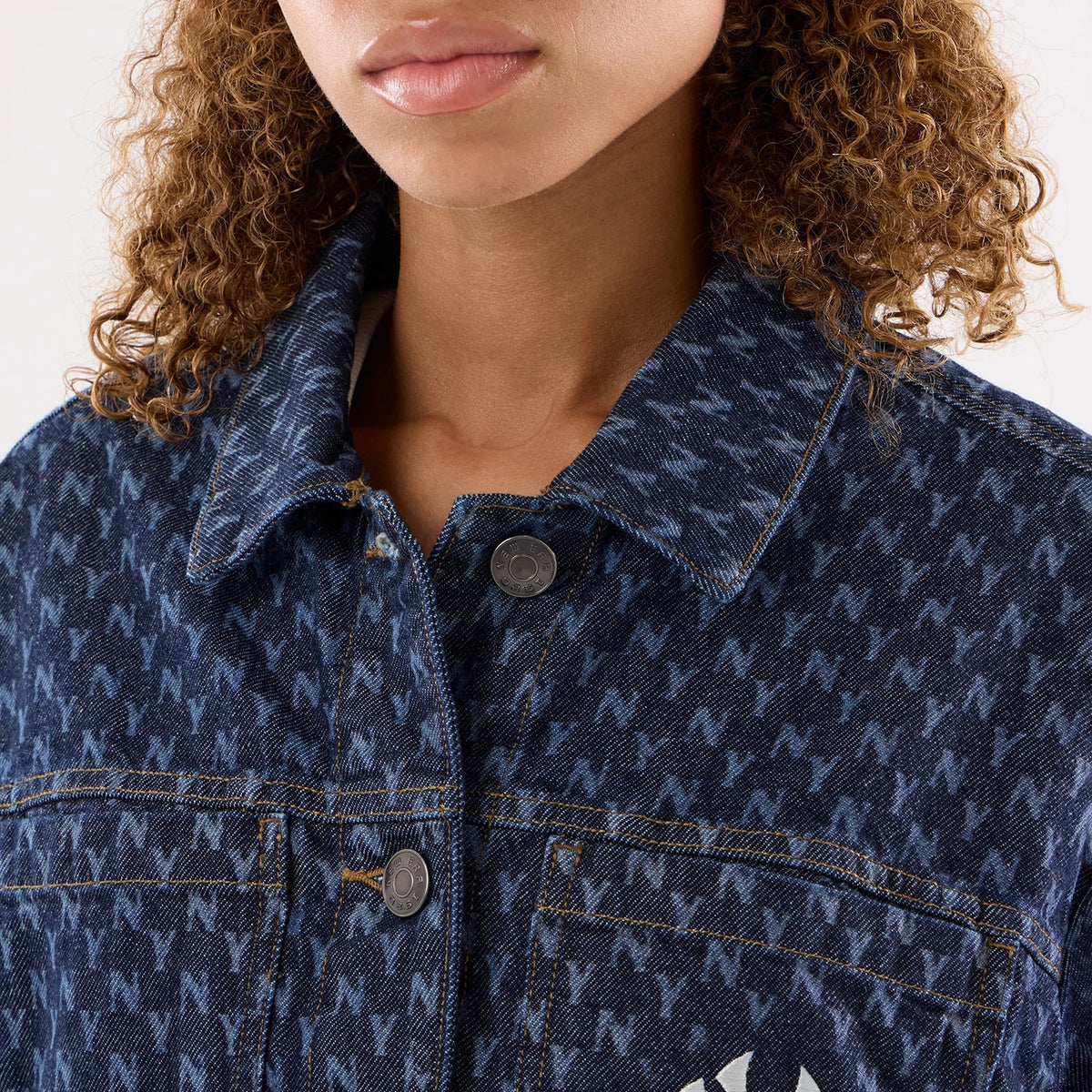 New Era New York Yankees Womens MLB Denim Navy Jacket, front view showing a navy denim fabric with an all-over N pattern, buttons fastening the jacket, and a white embroidered New York Yankees logo on the left chest pocket.