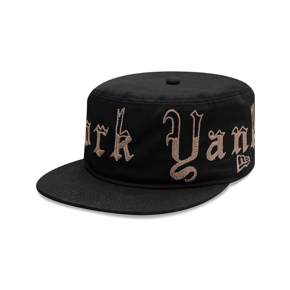 New Era New York Yankees MLB Heritage Black Pillbox Cap, three-quarter view showing the gold embroidered New York Yankees lettering in a script style across the black crown, with a flat black visor and the New Era flag logo on the side.
