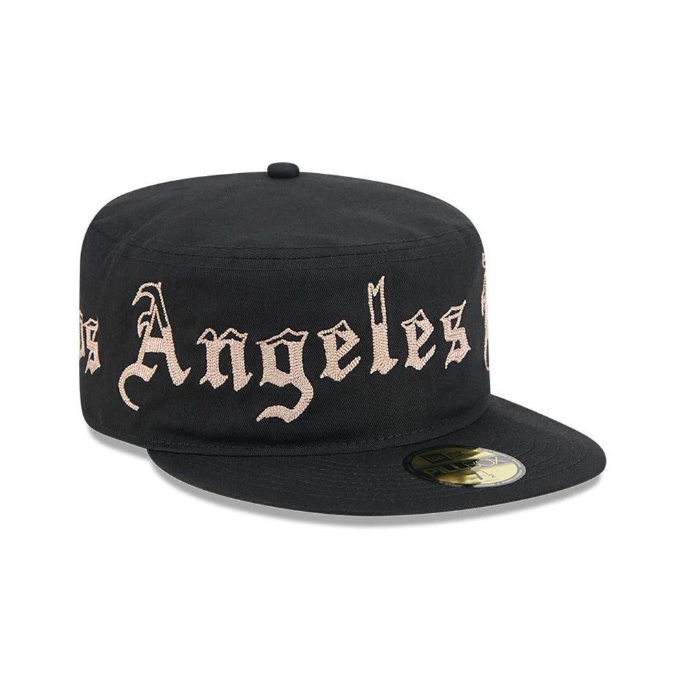 New Era LA Dodgers MLB Heritage Black Pillbox Cap, front view showing the beige Los Angeles Dodgers lettering embroidered across the front, structured black crown with a flat visor, and a gold 9FIFTY size sticker on the centre of the visor.