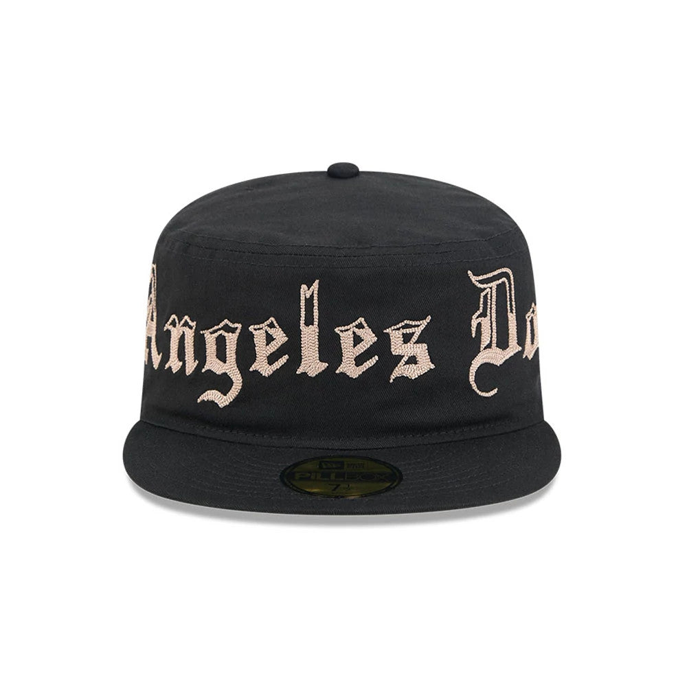 New Era LA Dodgers MLB Heritage Black Pillbox Cap, front view showing raised pink Los Angeles Dodgers script embroidery across the structured black crown, with a flat black visor and a black and gold Pillbox size sticker on the centre.