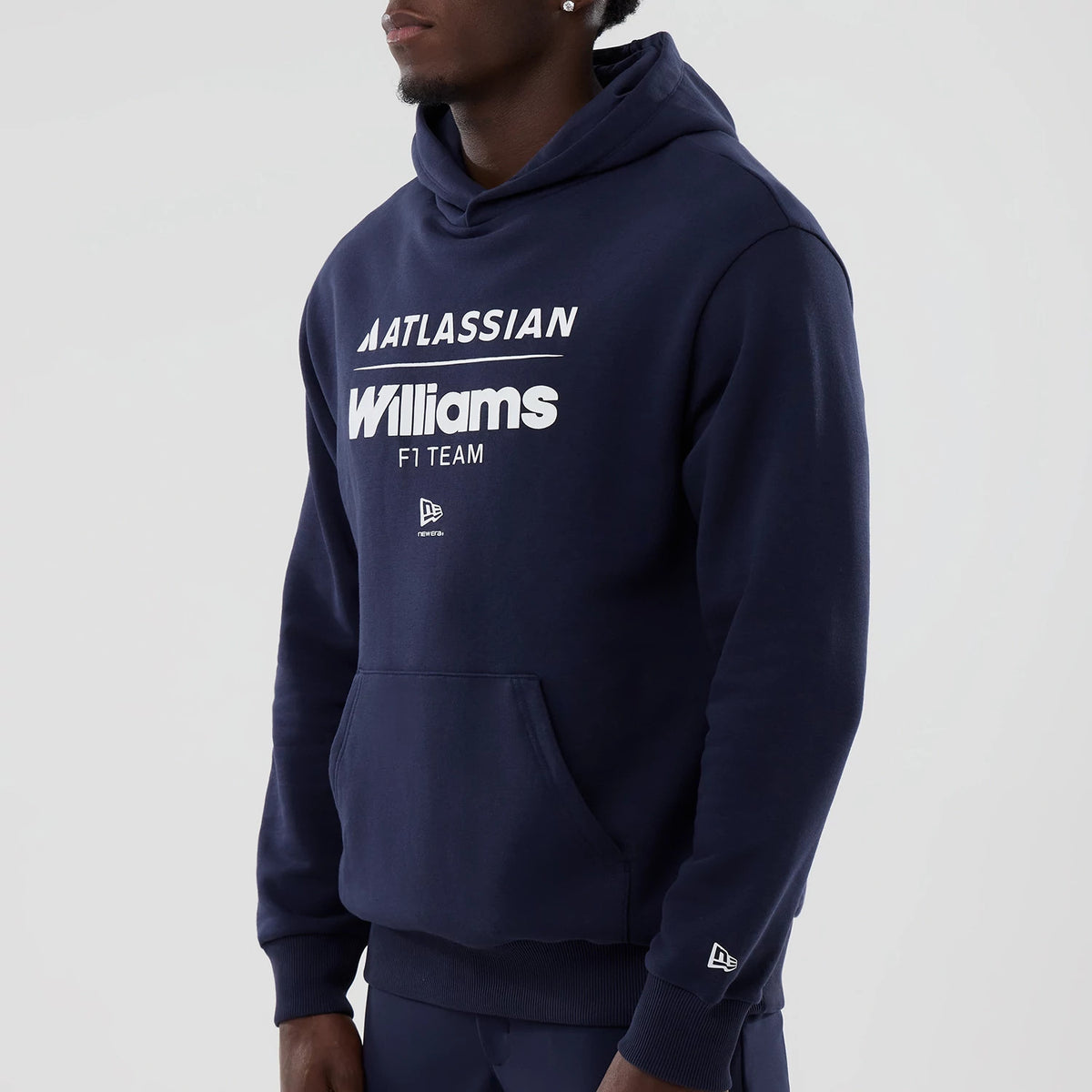 New Era Williams Navy Oversized Pullover Hoodie, front view on-model displaying white printed Williams F1 team graphics on the chest, New Era logo embroidered on the pocket, and another embroidered logo on the sleeve cuff.