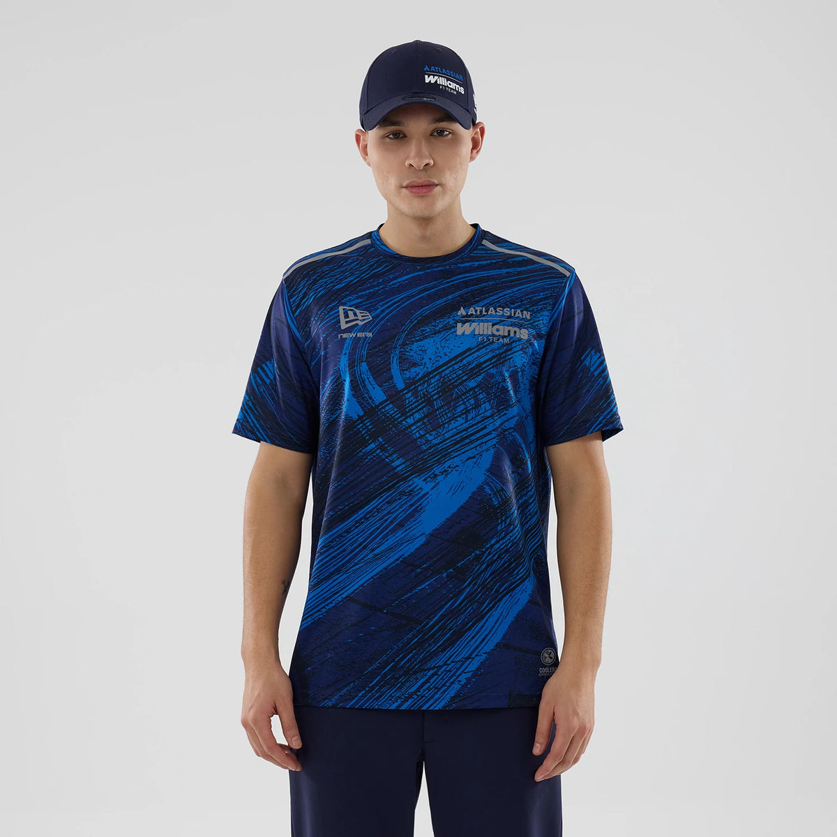 New Era Williams Navy Active T-Shirt, front view on-model displaying a blue and black abstract pattern across the fabric, an embroidered New Era logo on the right chest, and Williams logo prominently printed on the left chest.