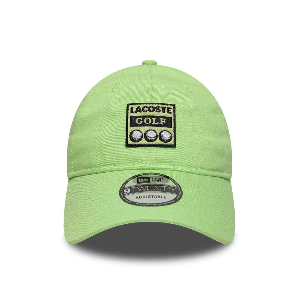 Lacoste X New Era Pastel Green 9TWENTY Adjustable Cap, front view showing a black and white Lacoste Golf patch with golf balls on the structured crown, curved visor with a 9TWENTY size sticker, and pastel green fabric throughout.