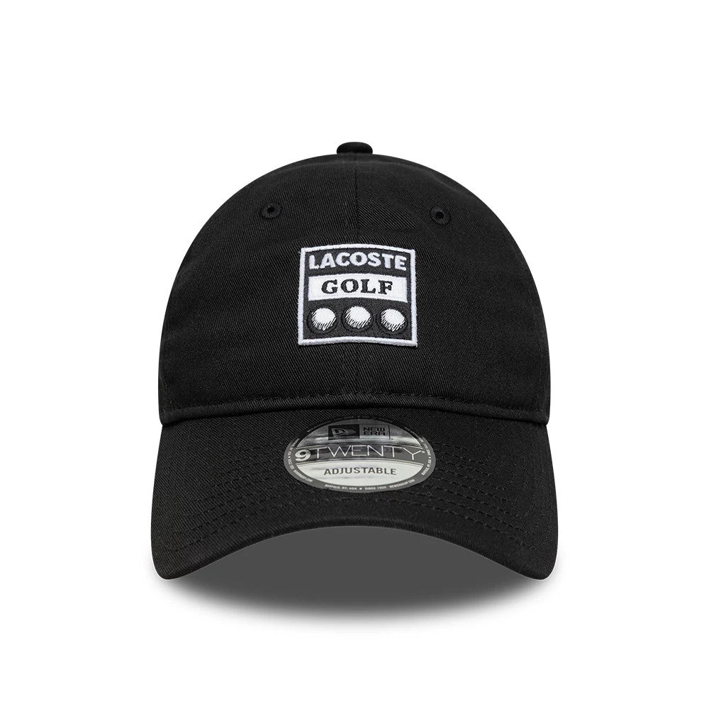 Lacoste X New Era Black 9TWENTY Adjustable Cap, front view showing the white embroidered Lacoste Golf graphic on the front panel, with a curved black visor featuring a 9TWENTY size sticker and matching top button and eyelets.