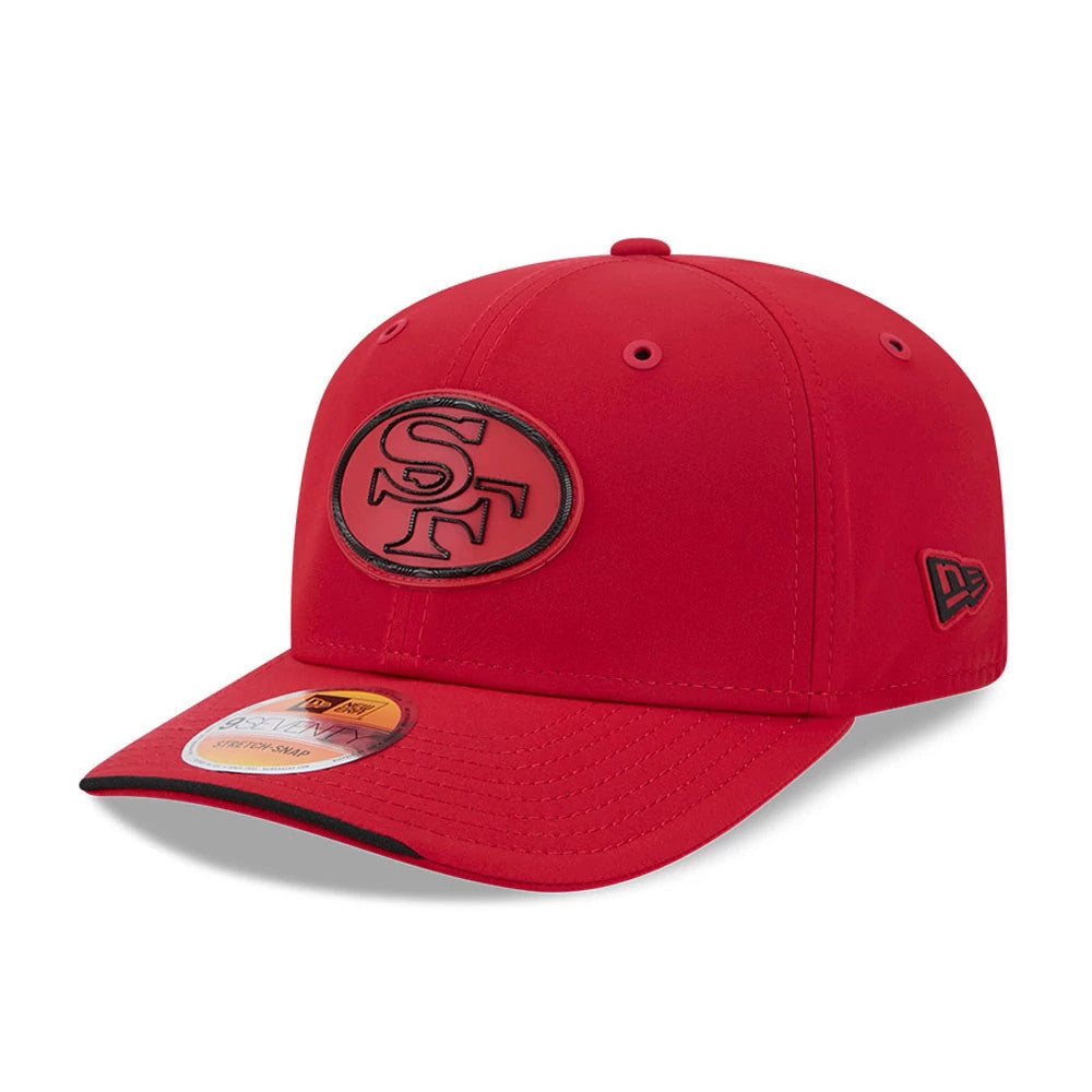 49ers NFL Sideline 2026 Red New Era 9SEVENTY Stretch Snap Adjustable Cap, three-quarter view showing the embroidered black SF logo on the front panel, with a curved red visor featuring a 9SEVENTY size sticker.