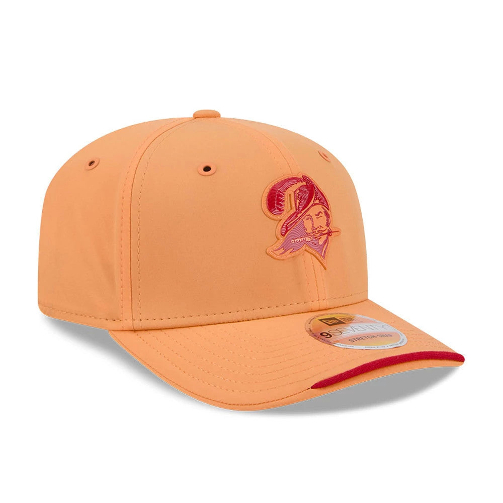 Buccaneers NFL Sideline 2026 Orange New Era 9SEVENTY Stretch Snap Adjustable Cap, three-quarter view showing the red embroidered Buccaneers logo on the front panel, with an orange curved visor and orange eyelets, plus a 9SEVENTY size sticker.