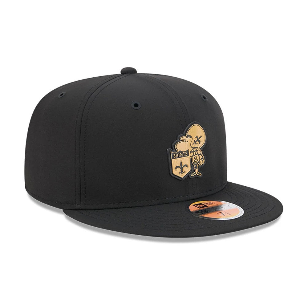New Orleans Saints NFL Sideline 2026 Black New Era 59FIFTY Fitted Cap, three-quarter view featuring a gold and black embroidered Saints logo on the front panel, a black flat visor with a gold 59FIFTY size sticker, and a structured black crown.