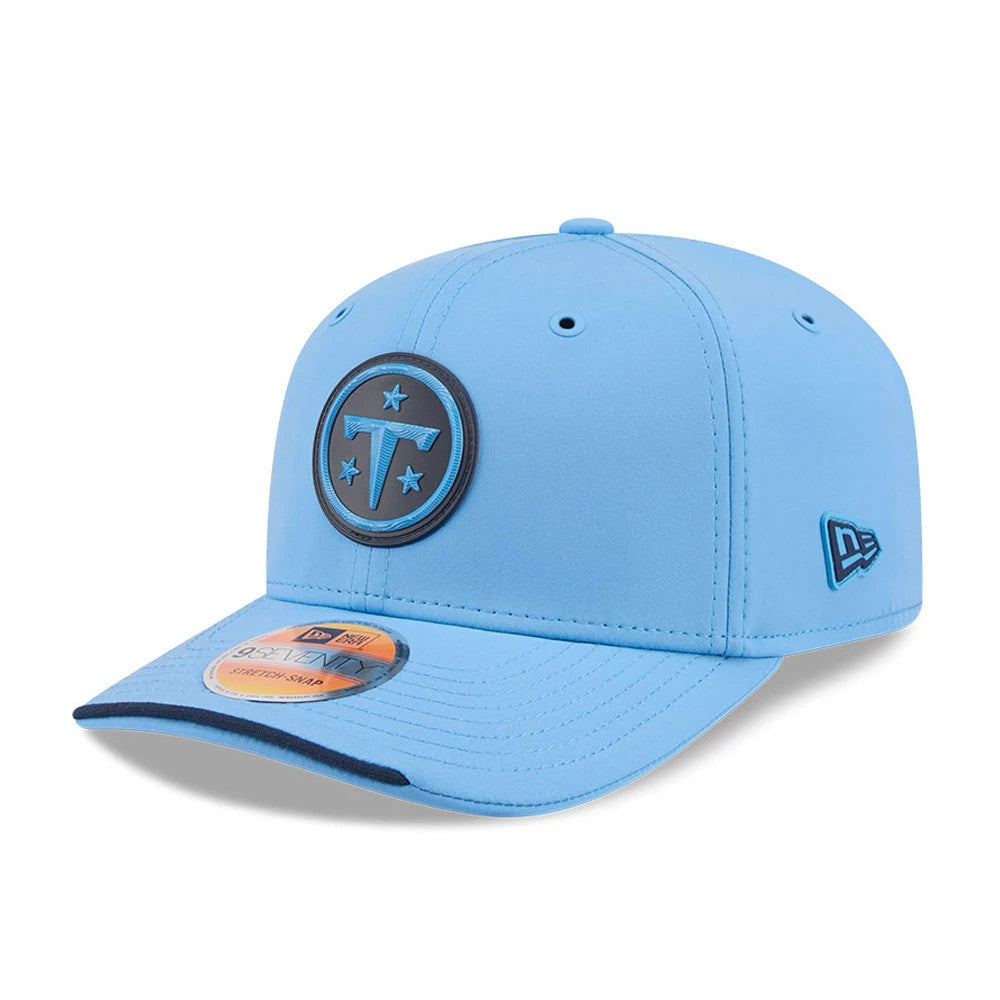 Titans NFL Sideline 2026 Pastel Blue New Era 9SEVENTY Stretch Snap Adjustable Cap, three-quarter view showing a raised black and blue Titans logo on the front panel, dark blue visor edge, and a New Era flag logo embroidered on the left side.