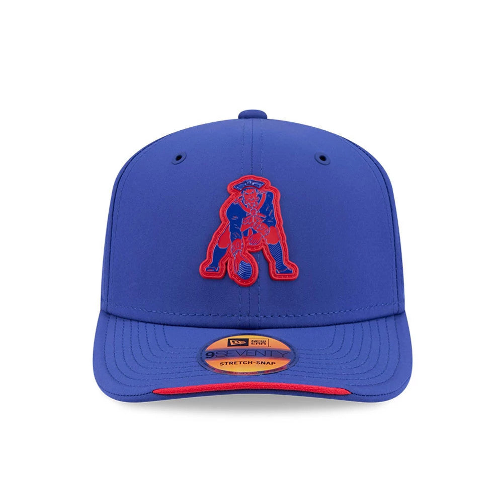 Patriots NFL Sideline 2026 Blue New Era 9SEVENTY Stretch Snap Adjustable Cap, front view showing a red embroidered Patriot logo on the structured blue crown, with a blue visor featuring a 9SEVENTY size sticker and red undervisor edge.
