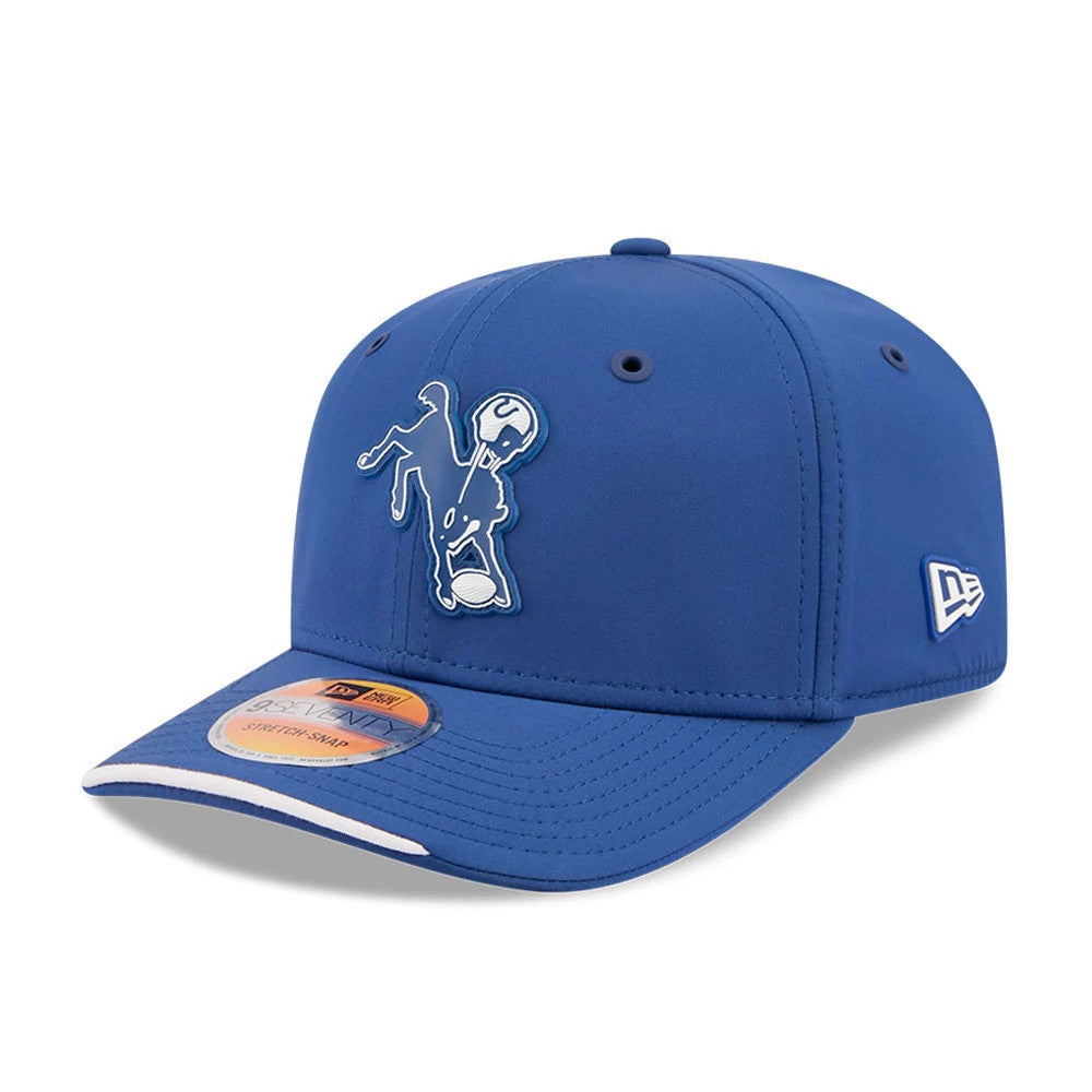 Colts NFL Sideline 2026 Blue New Era 9SEVENTY Stretch Snap Adjustable Cap, front view showing a raised white and blue embroidered horse logo on the front panel, with a curved blue visor and a 9SEVENTY size sticker on the top.