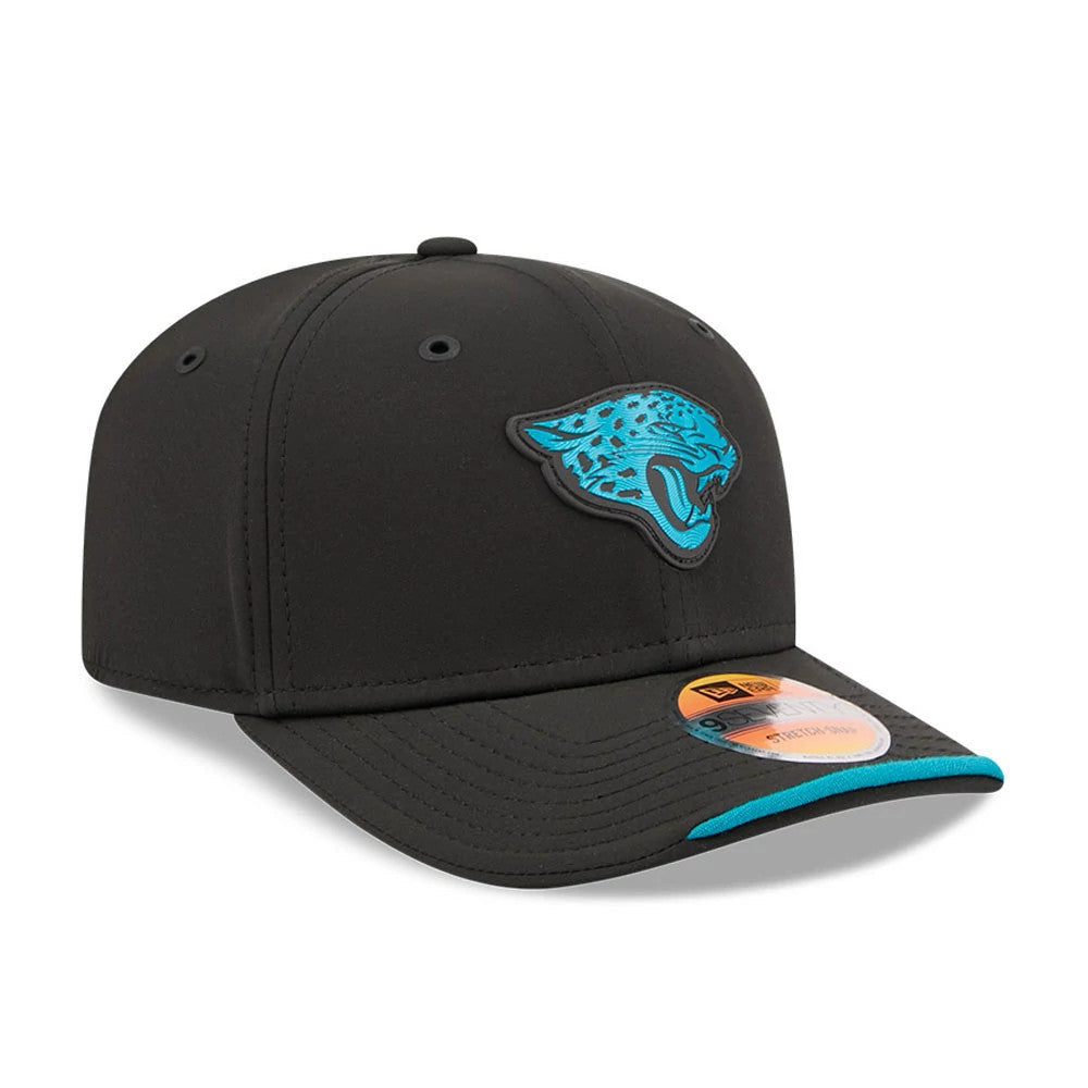Jaguars NFL Sideline 2026 Black New Era 9SEVENTY Stretch Snap Adjustable Cap, three-quarter view showing the raised teal jaguar logo on the front panel, black visor with teal edging, and the 9SEVENTY size sticker on the visor.
