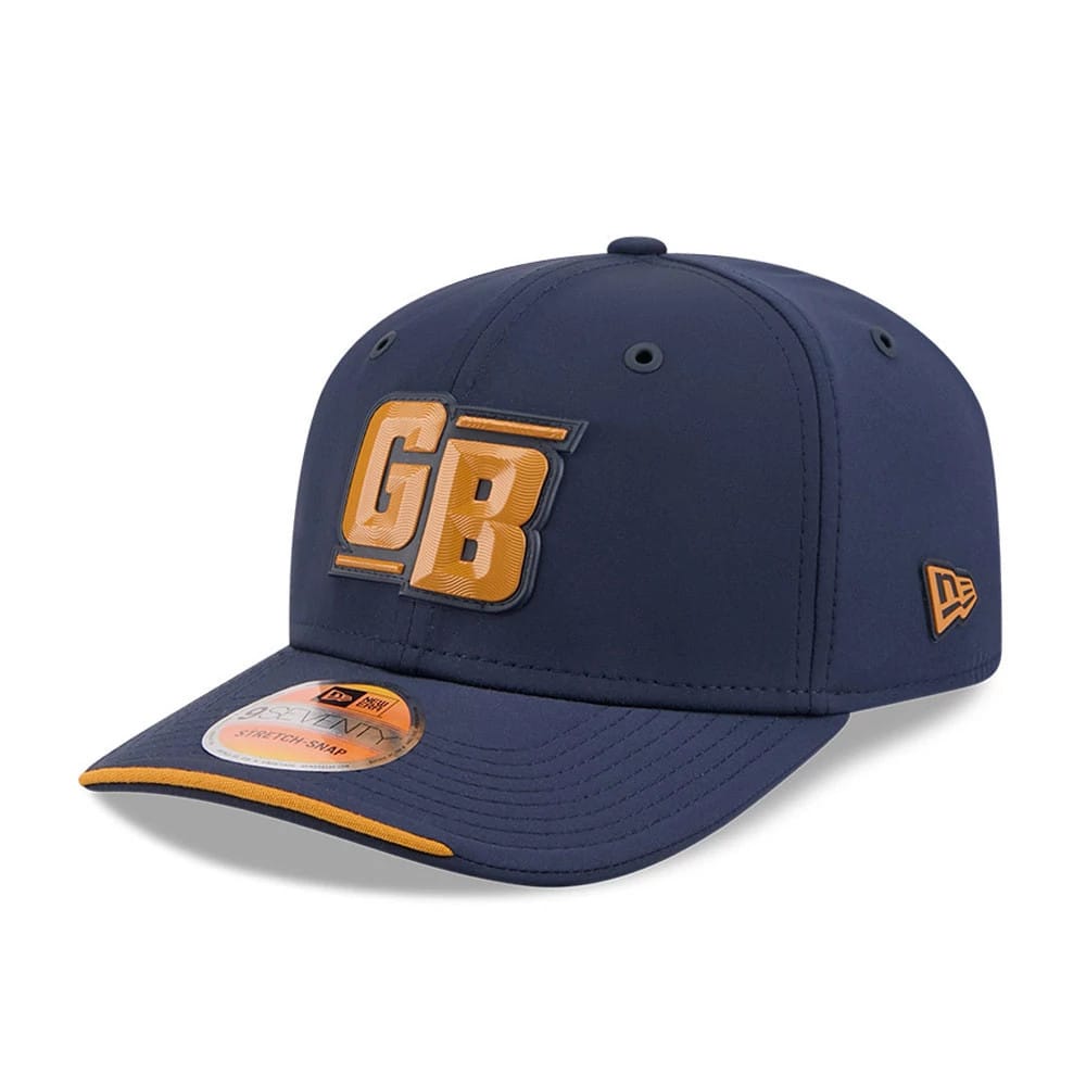 Packers NFL Sideline 2026 Dark Blue New Era 9SEVENTY Stretch Snap Adjustable Cap, three-quarter view showing the raised gold GB logo on the front panel, the matching dark blue visor with gold edging, and the New Era flag logo on the left side.