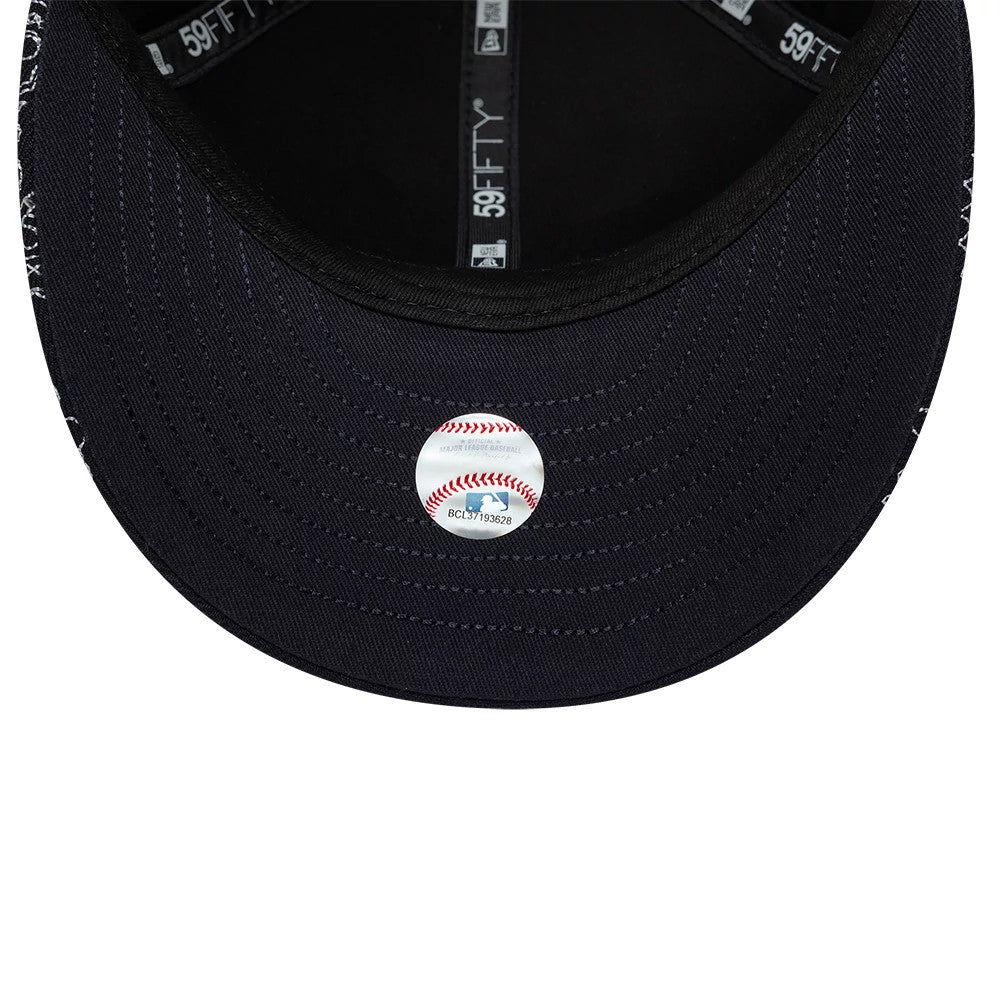 New York Yankees MLB All Over Paisley Navy Low Profile New Era 59FIFTY Fitted Cap, inside view showing the black undervisor with detailed stitching, grey taping marked with 59FIFTY branding, and a baseball design sticker in the centre.