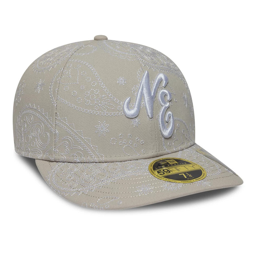 New Era All Over Paisley Cream Low Profile 59FIFTY Fitted Cap, three-quarter view showing the raised white embroidered ‘NE’ initials on the front panel, intricate white paisley pattern across the crown and visor, and gold 59FIFTY size sticker.
