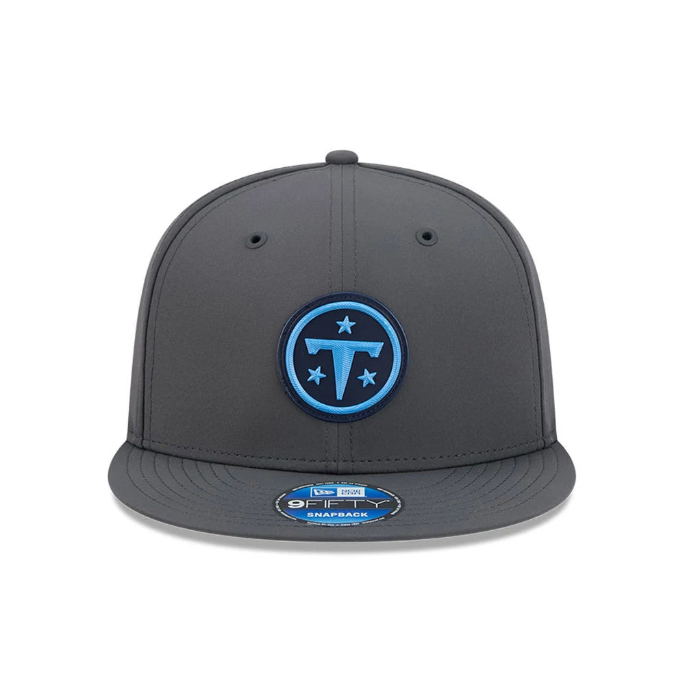 Titans NFL Sideline 2026 Charcoal New Era 9FIFTY Snapback Adjustable Cap, front view showing the blue embroidered Titans logo on the structured charcoal front panel, with a matching charcoal visor and a 9FIFTY size sticker on the visor.