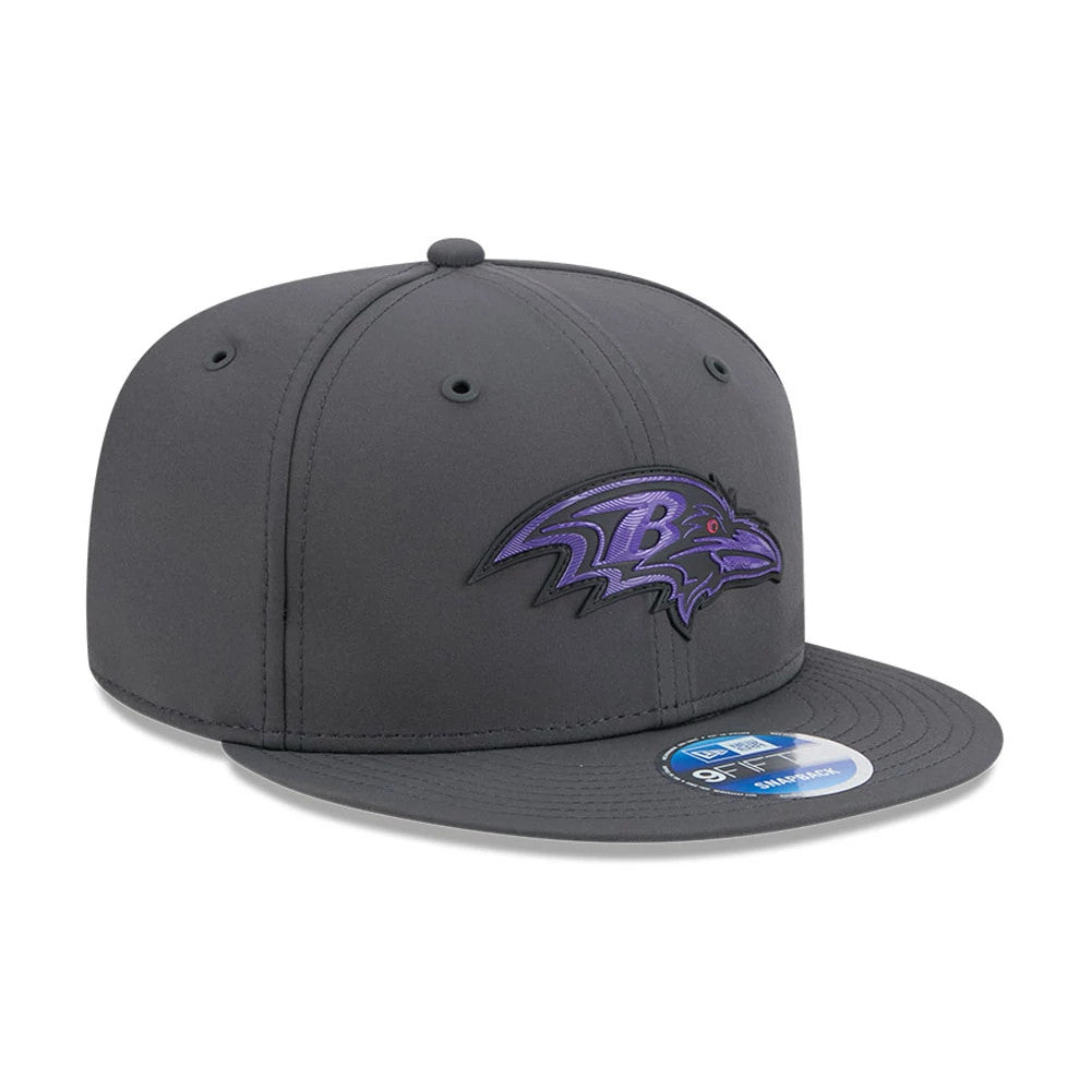 Ravens NFL Sideline 2026 Charcoal New Era 9FIFTY Snapback Adjustable Cap, front view showing the raised purple and black embroidered Ravens logo on the front panel, charcoal flat visor with a 9FIFTY size sticker, and structured crown.