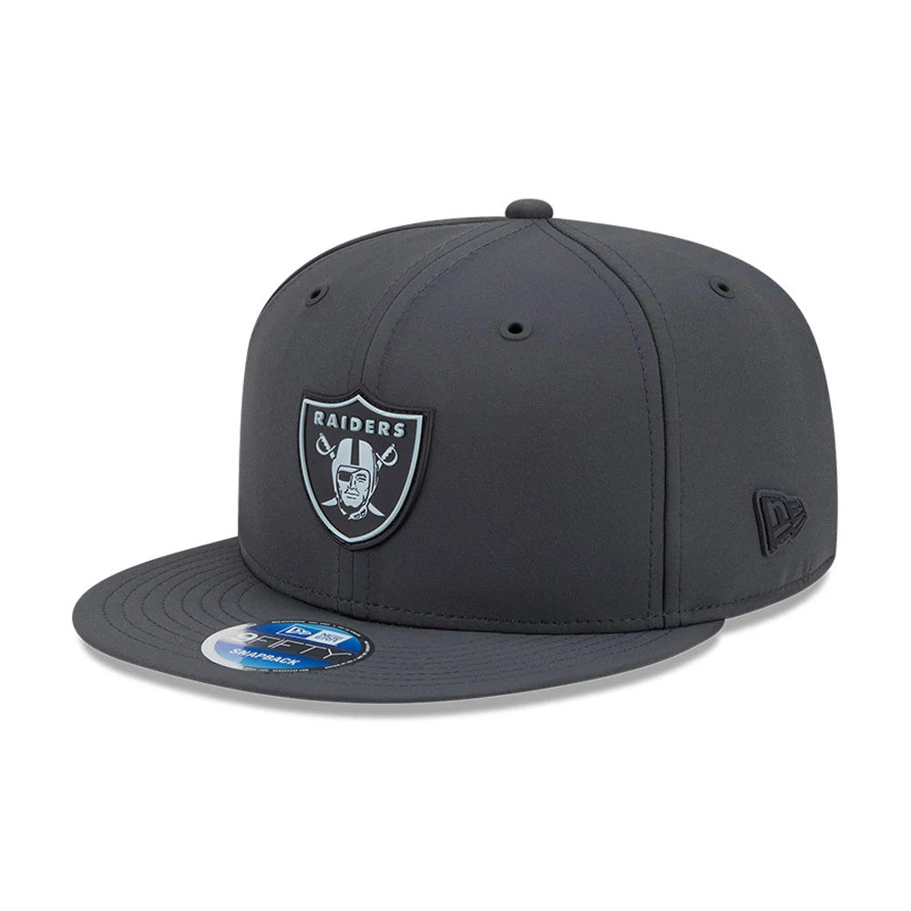 Raiders NFL Sideline 2026 Charcoal New Era 9FIFTY Snapback Adjustable Cap, front view showing the raised black and white Raiders shield logo on the structured charcoal crown, a flat charcoal visor with a 9FIFTY size sticker.