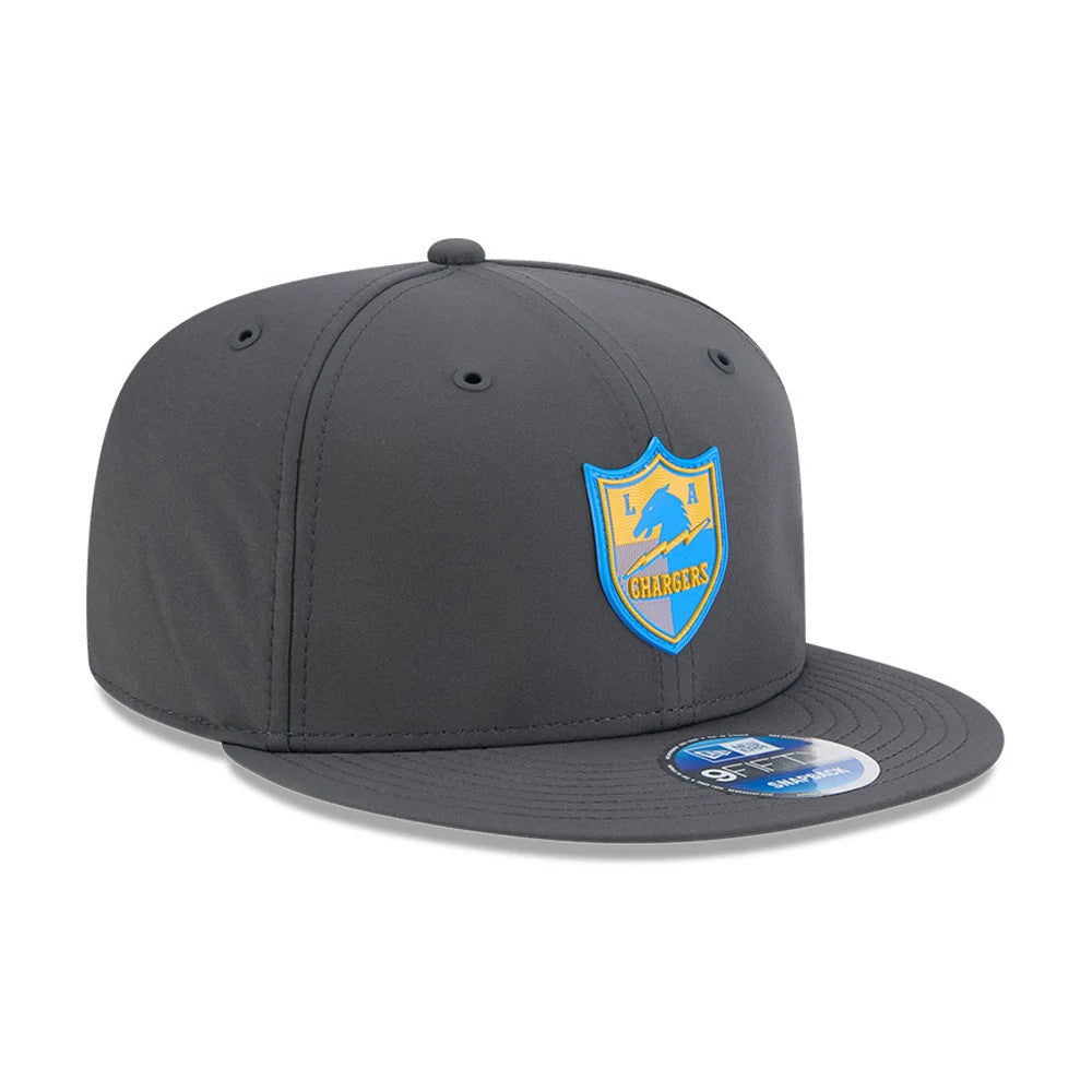 LA Chargers NFL Sideline 2026 Charcoal New Era 9FIFTY Snapback Adjustable Cap, three-quarter view showing the blue and yellow Chargers shield logo embroidered on the front panel, with a matching charcoal flat visor and a 9FIFTY size sticker.