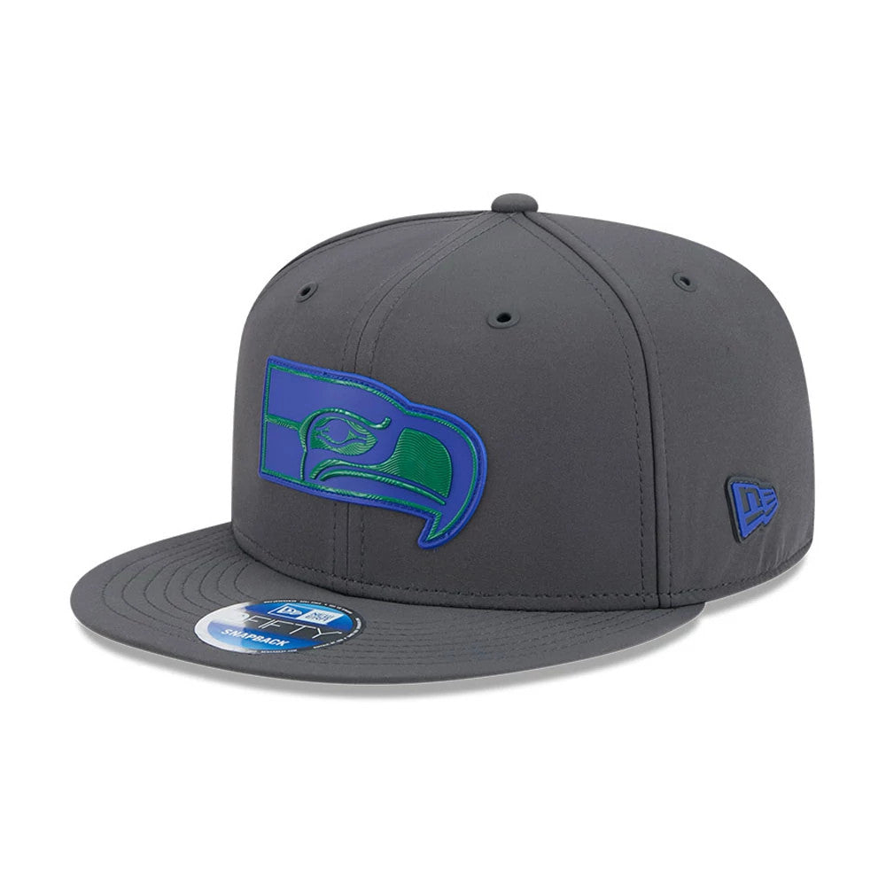 Seahawks NFL Sideline 2026 Charcoal New Era 9FIFTY Snapback Adjustable Cap, three-quarter view showing the raised blue and green embroidered Seahawks logo on the front panel, flat charcoal visor with a 9FIFTY size sticker.