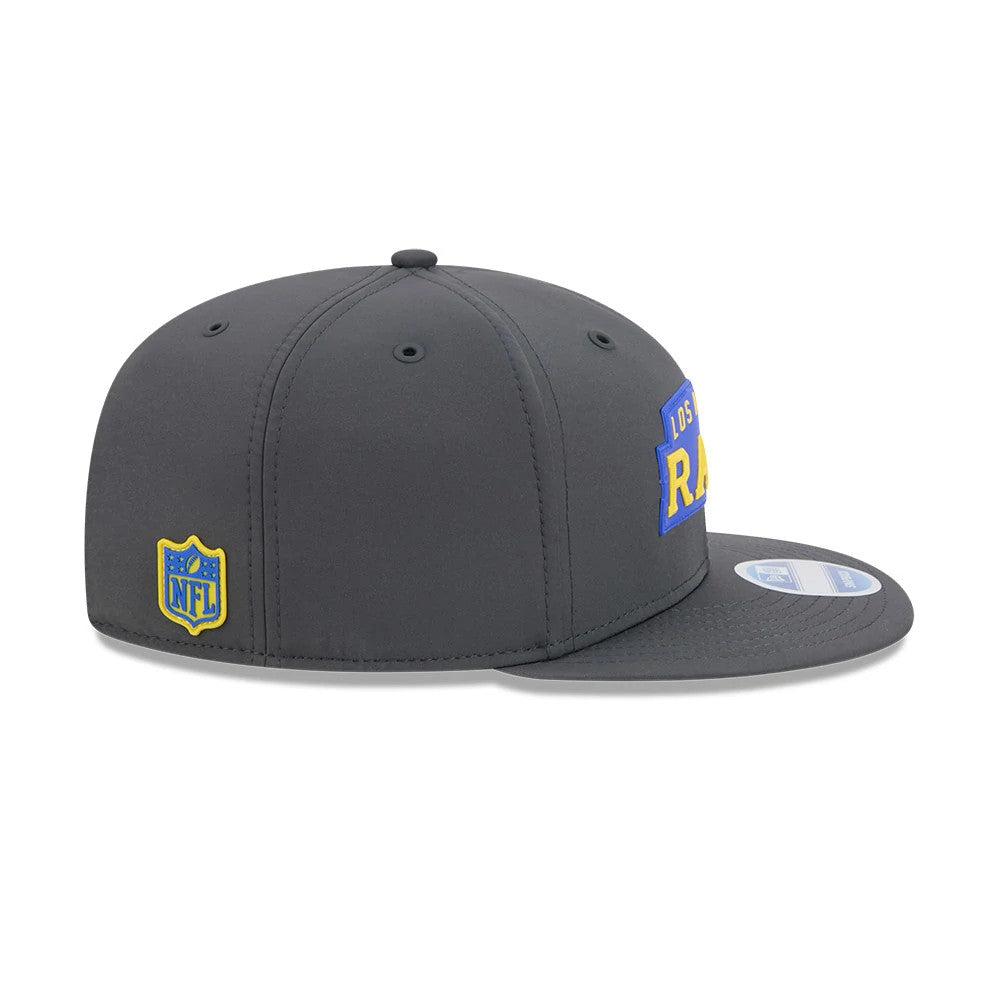LA Rams NFL Sideline 2026 Charcoal New Era 9FIFTY Snapback Adjustable Cap, side view showing the golden yellow NFL shield logo on the left panel, a structured charcoal crown, and a straight flat visor with a 9FIFTY size sticker.