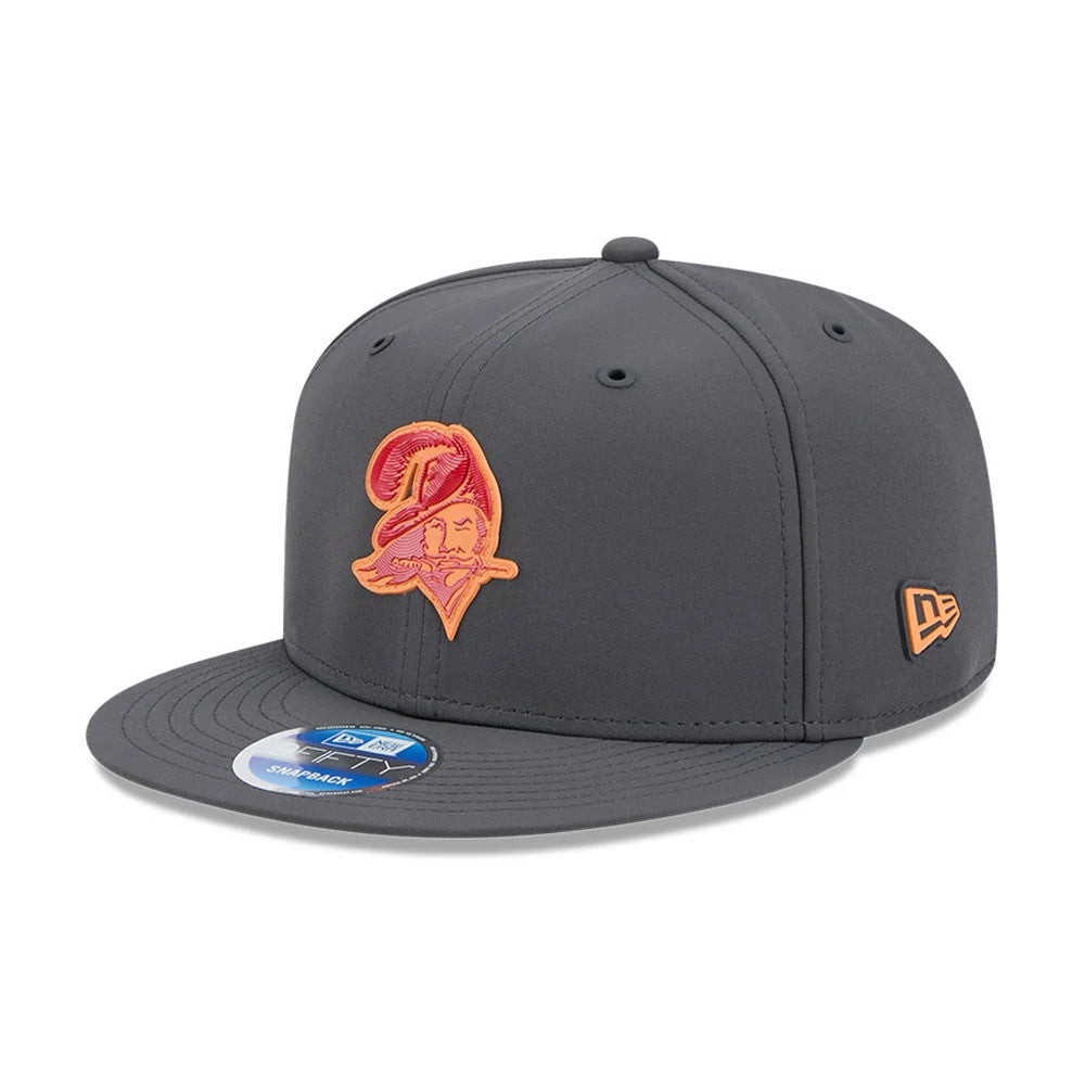 Buccaneers NFL Sideline 2026 Charcoal New Era 9FIFTY Snapback Adjustable Cap, front view showing an orange embroidered Buccaneers logo on the front panels, a flat charcoal visor with a 9FIFTY size sticker, and the New Era flag logo on the left side.