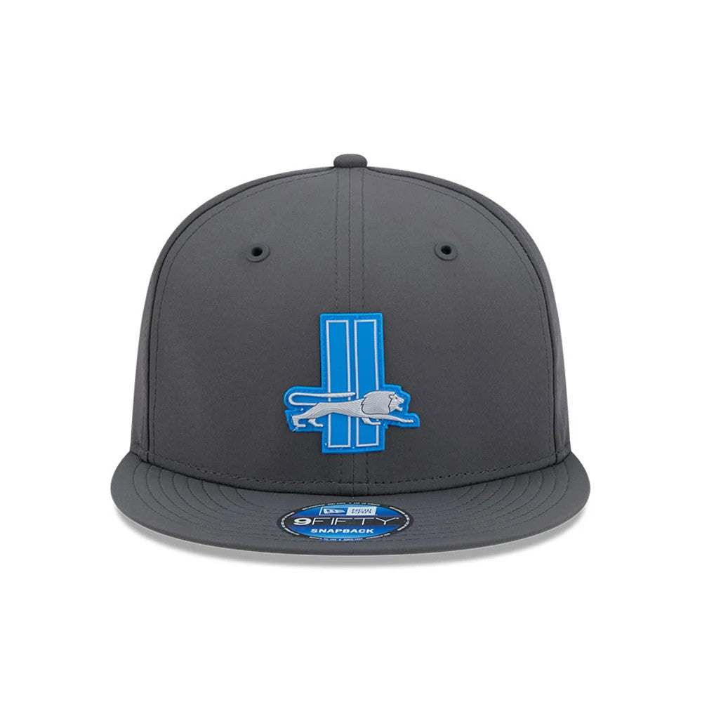 Detroit Lions NFL Sideline 2026 Charcoal New Era 9FIFTY Snapback Adjustable Cap, front view showing a blue and silver embroidered Detroit Lions logo on the crown, charcoal flat visor, and a 9FIFTY size sticker on the visor.