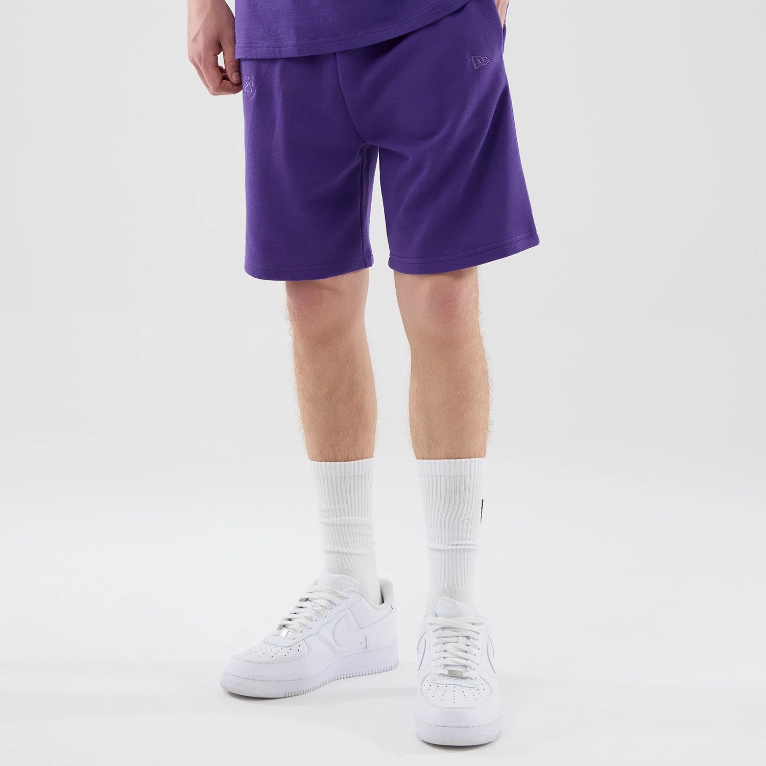 The model is wearing these NBA League Essential LA Lakers Oversized Shorts in purple. 1