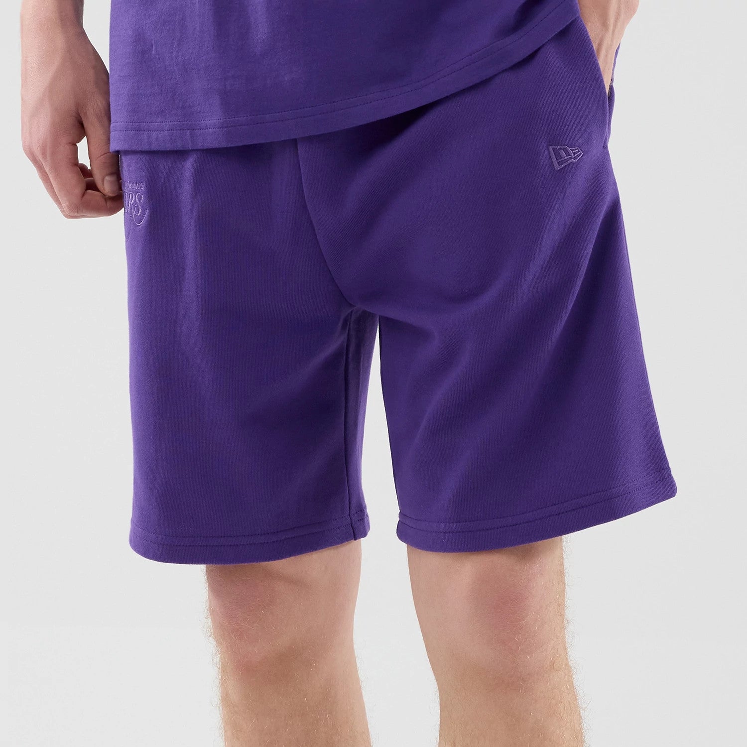 The model is wearing these NBA League Essential LA Lakers Oversized Shorts in purple. 3
