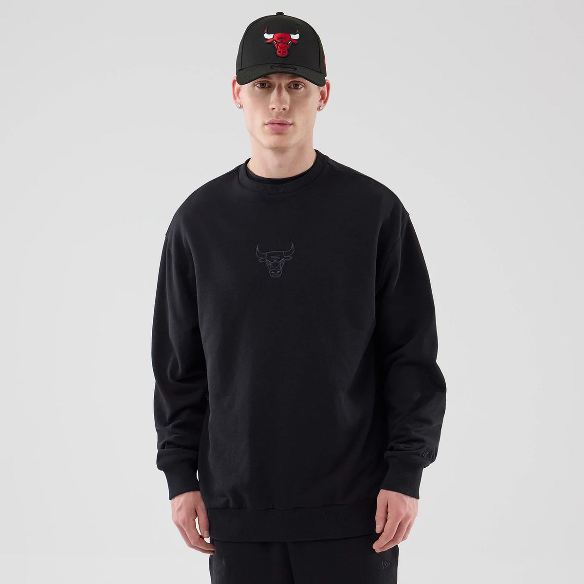 The model is wearing this NBA League Essential Chicago Bulls Oversized Crew Neck Sweater in black. 1