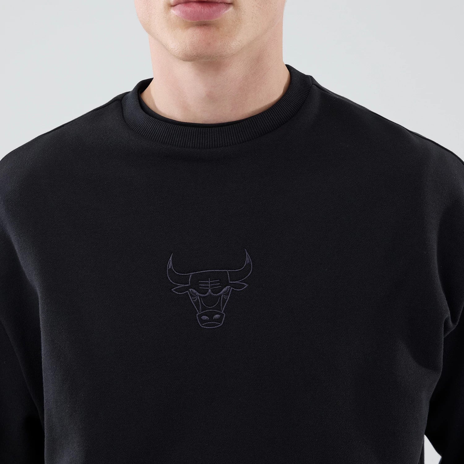 The model is wearing this NBA League Essential Chicago Bulls Oversized Crew Neck Sweater in black. 4