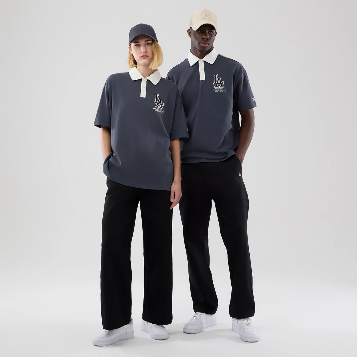 New Era LA Dodgers MLB Grey Polo T-Shirt, front view on-model showing a grey polo with a contrasting white collar and placket, the embroidered LA Dodgers logo on the left chest, paired with black trousers and white trainers.