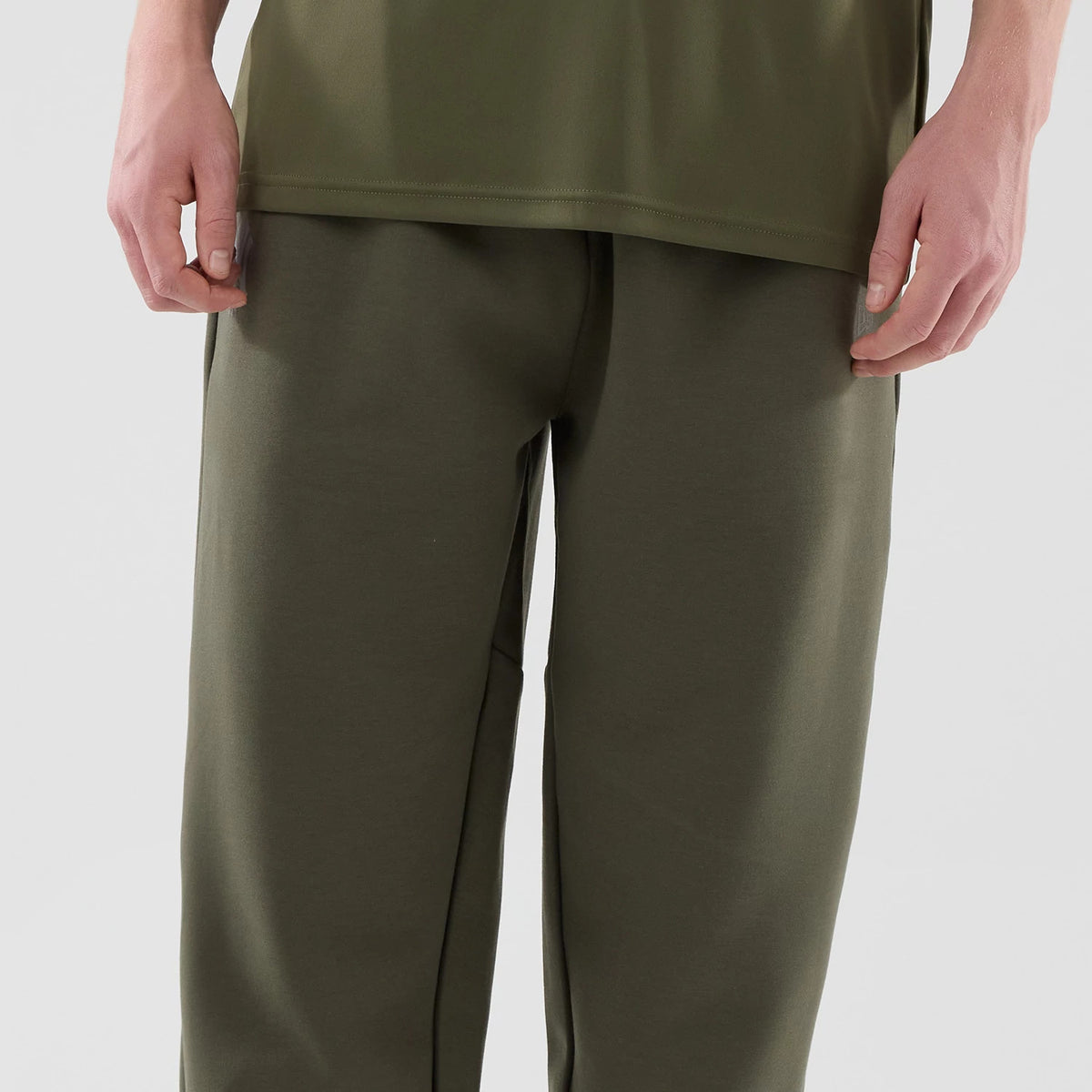 New Era New York Yankees MLB Core Plus Green Joggers, front view on a model displaying a relaxed fit with a plain design and an elastic waistband, highlighting the olive green colour and fabric texture near the waist and thighs.