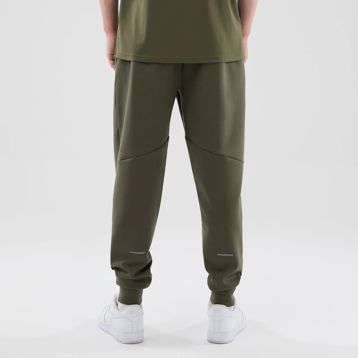New Era New York Yankees MLB Core Plus Green Joggers, rear view on a model showing the curved seam detail across the back of the legs, elasticised cuffs at the ankles, and reflective strip above the cuffs for added visibility.
