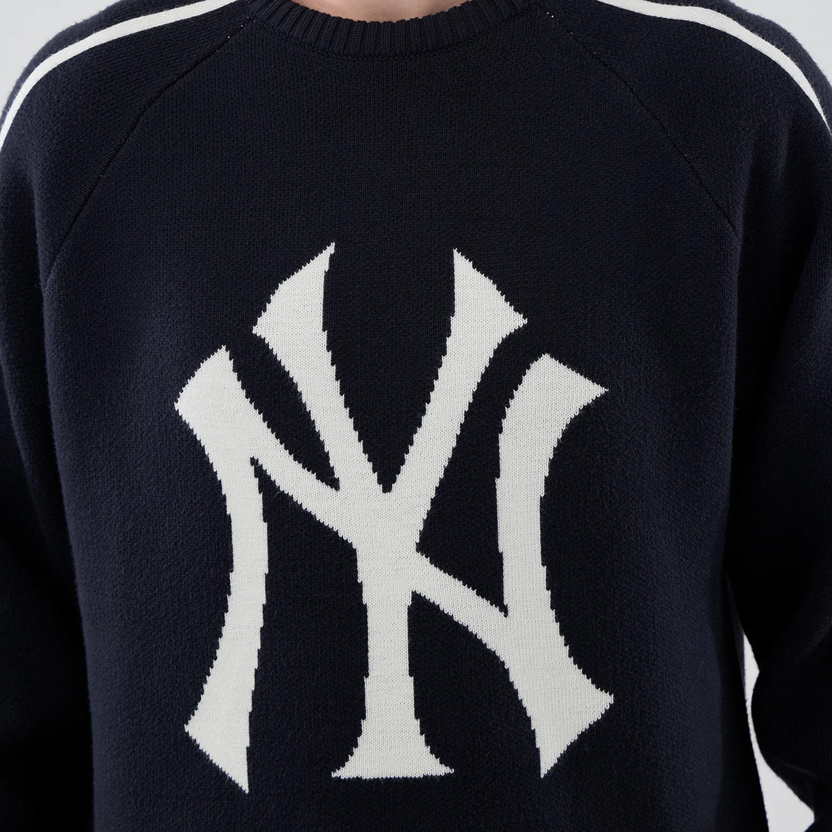 New Era New York Yankees MLB Knit Navy Knitted Sweater, front view showing a large white knitted NY logo on the chest, with ribbed crew neck and white shoulder stripes on the navy background.