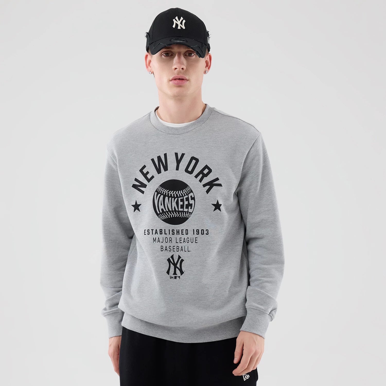 The model is wearing this MLB Graphic New York Yankees Oversized Crew Neck Sweater in grey. 3