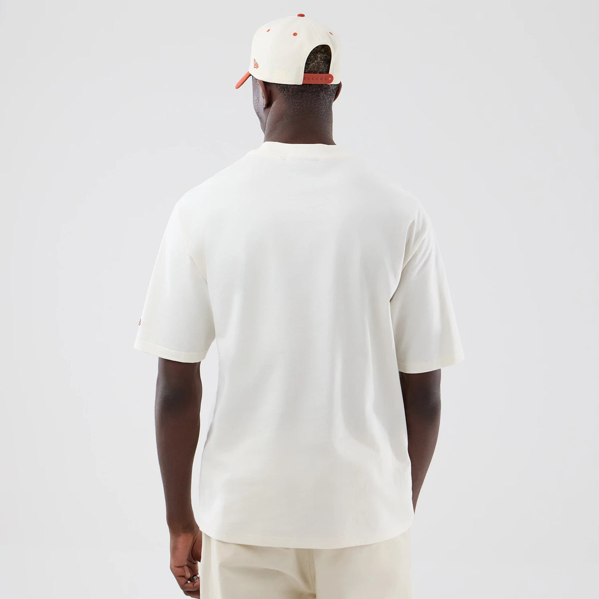 New Era New York Yankees MLB Arch Graphic Open White Oversized T-Shirt, back view on a model styled with a matching cap, showing the plain white oversized back, short sleeves and a small embroidered logo on the left sleeve.