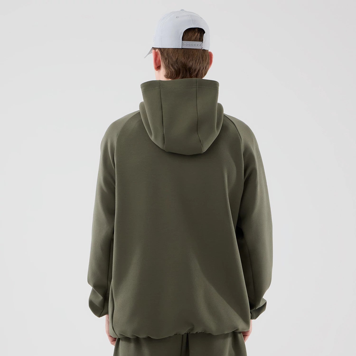 New Era New York Yankees MLB Core Plus Green Full Zip Hoodie, back view showing a plain green back with a large hood at the top, raglan sleeves offering casual styling, and a model wearing a light grey cap completing the ensemble.