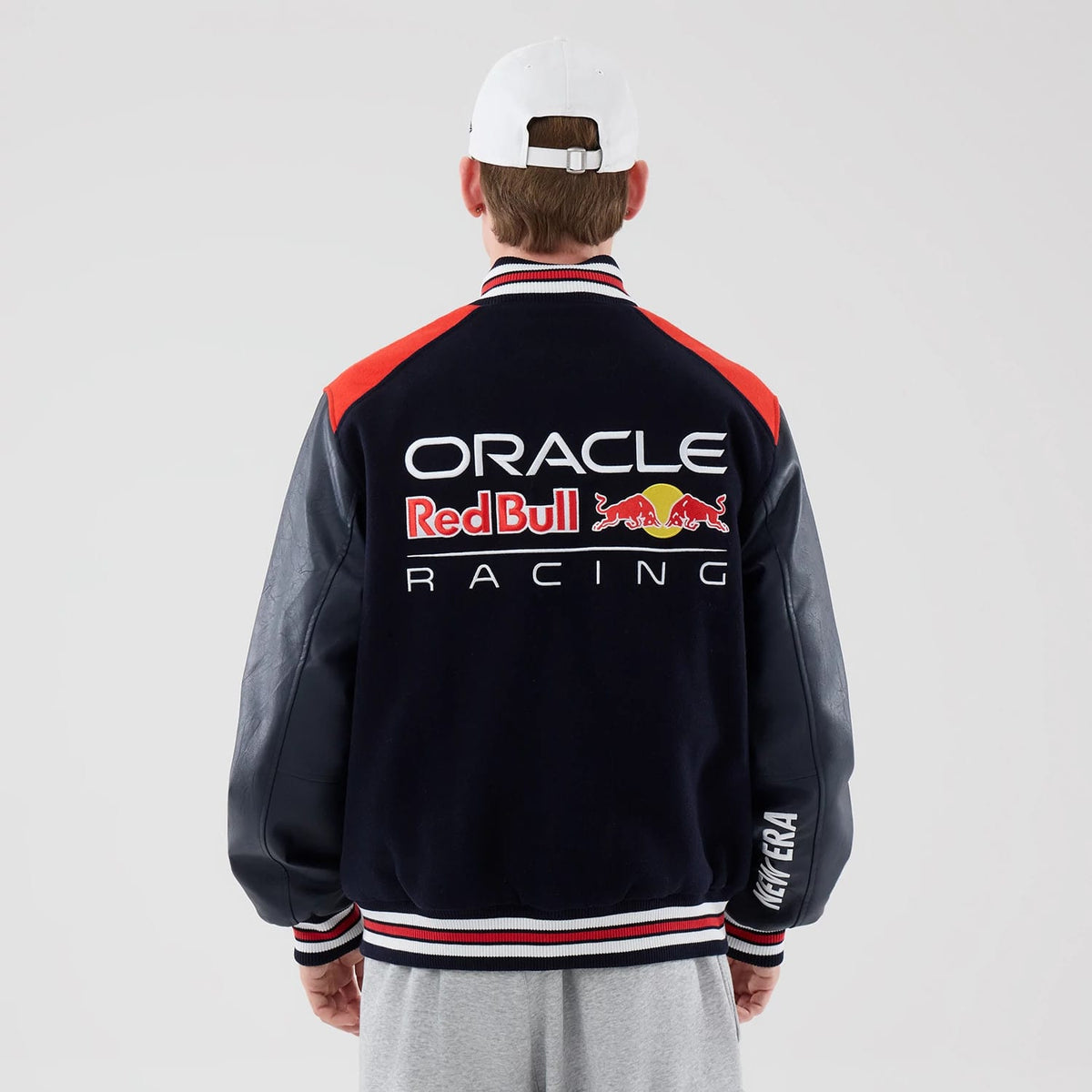 The model is wearing this Red Bull Racing wordmark Varsity Jacket in dark blue. 2