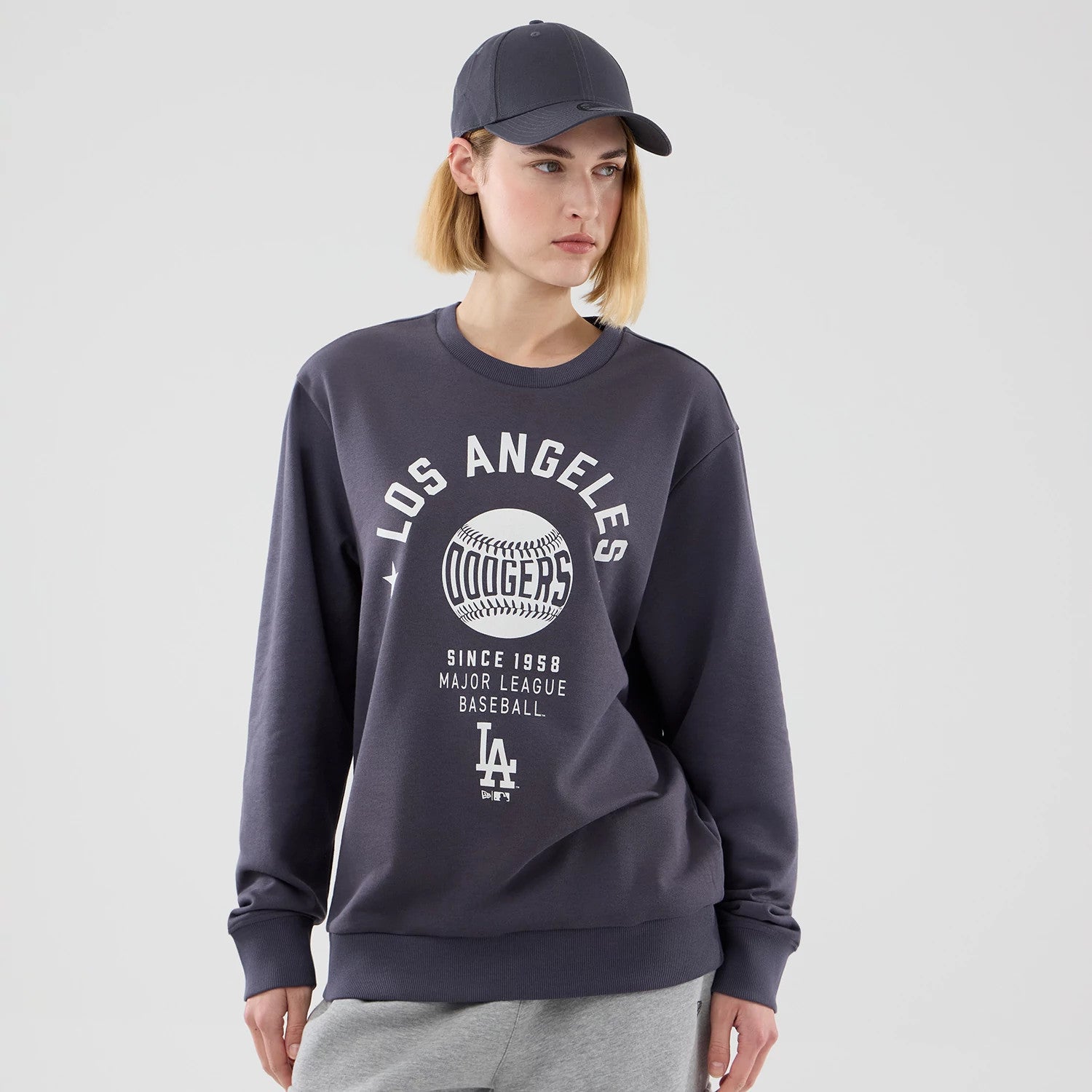 The model is wearing this MLB Graphic LA Dodgers Oversized Crew Neck Sweater in grey. 4