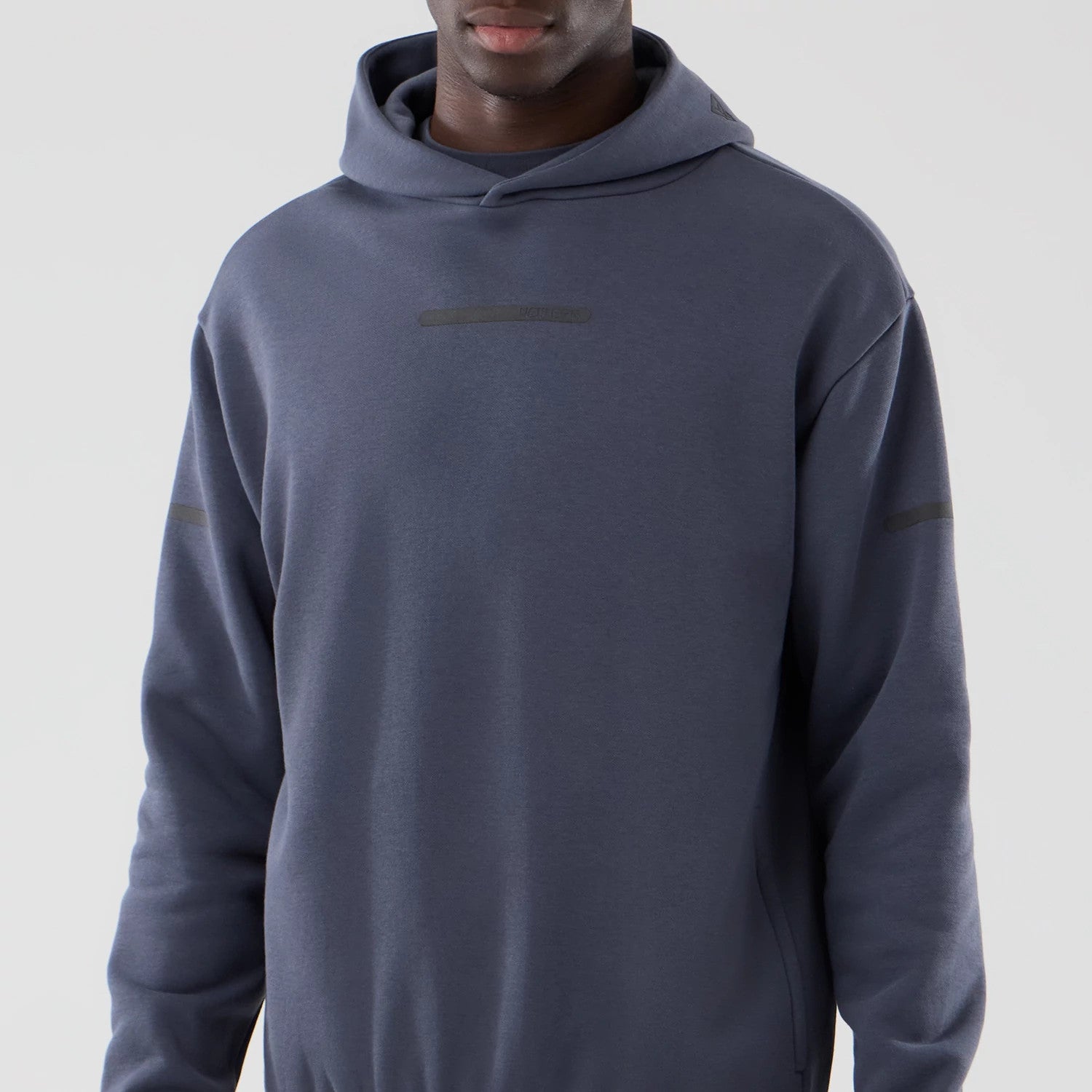The model is wearing this New Era Tech Oversized Pullover Hoodie in grey. 3