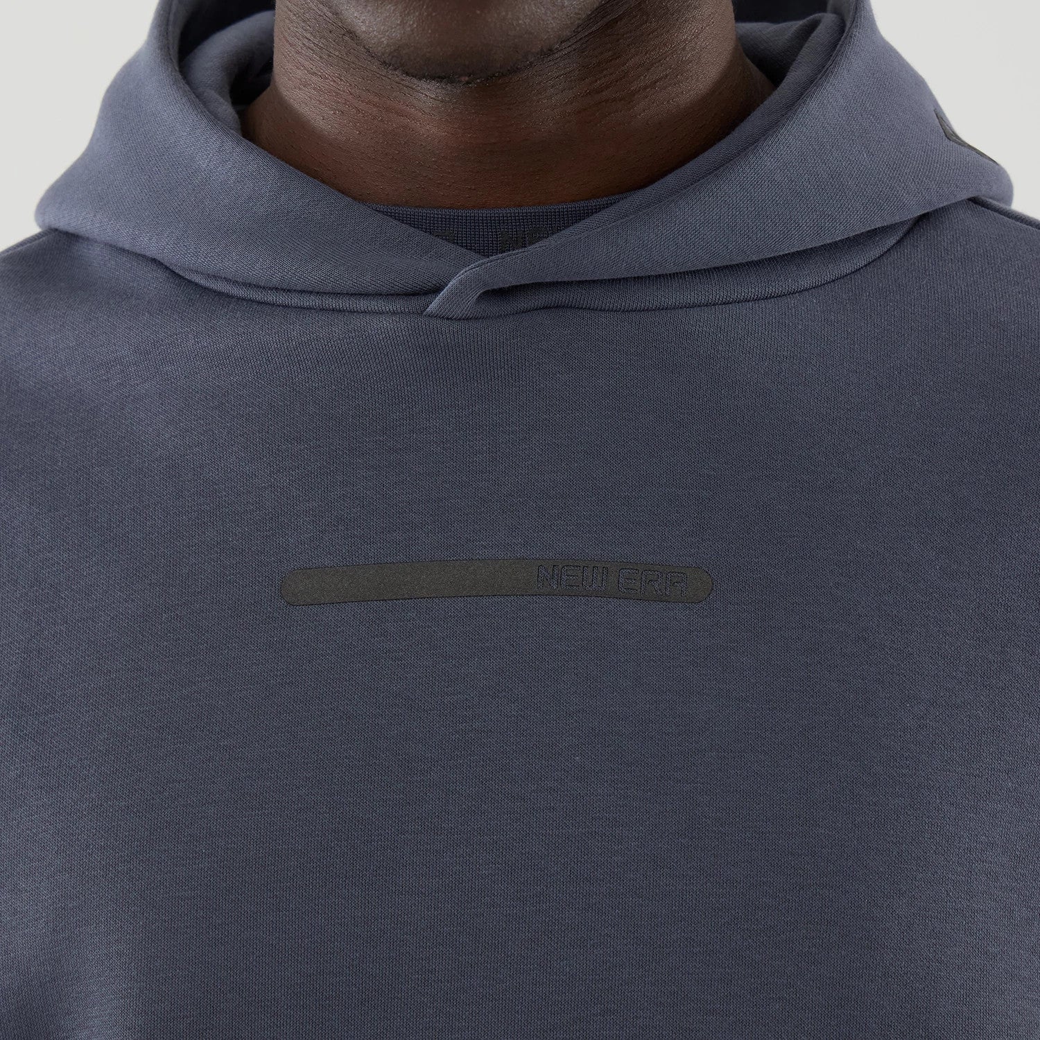 The model is wearing this New Era Tech Oversized Pullover Hoodie in grey. 4