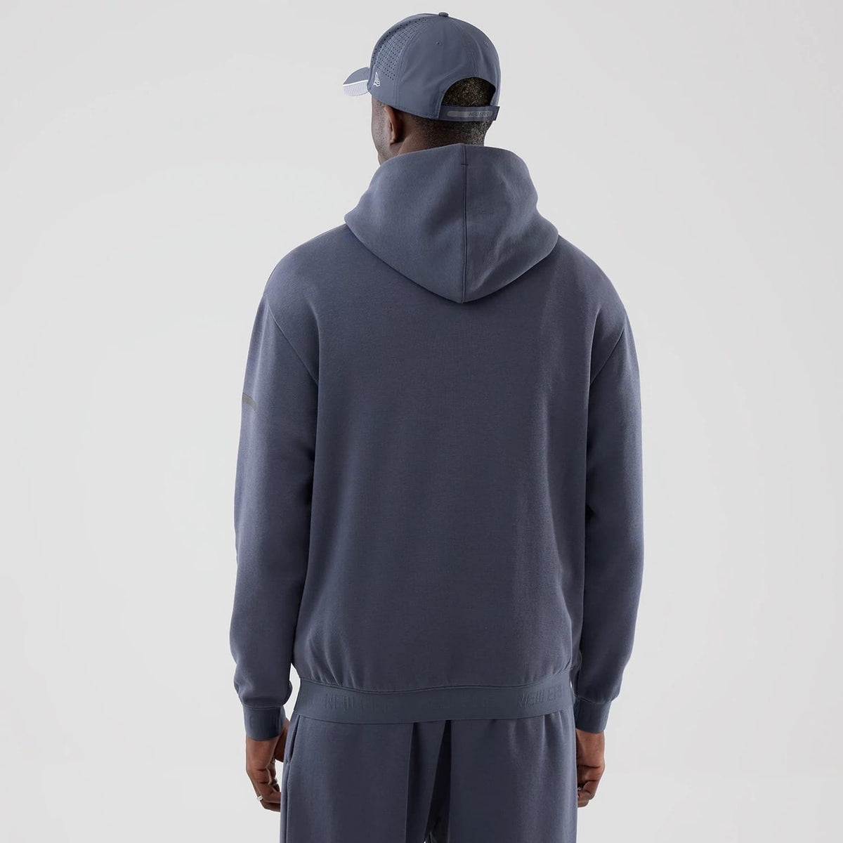 The model is wearing this New Era Tech Oversized Pullover Hoodie in grey. 2