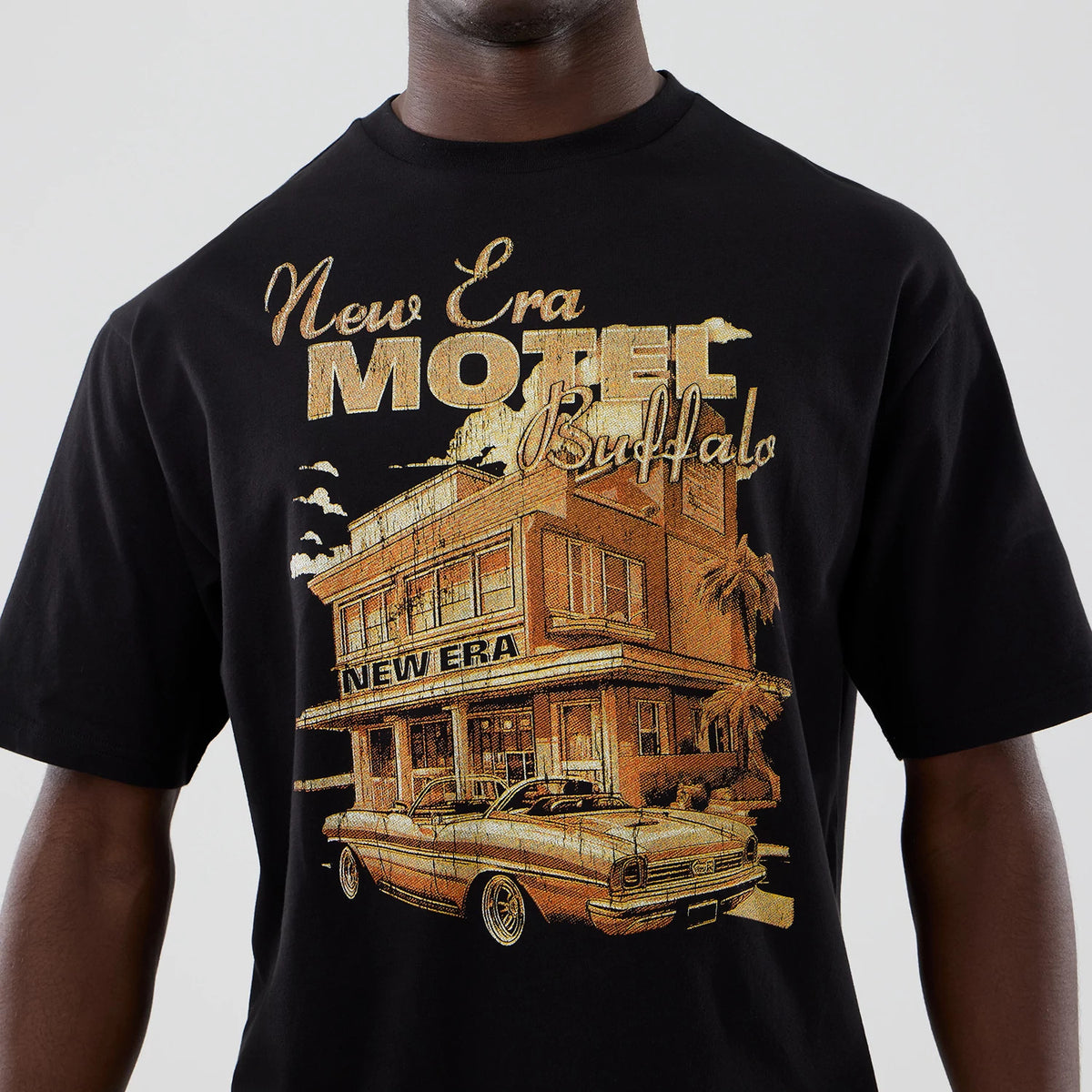 The model is wearing this New Era Motor Graphic Oversized T-Shirt in black. 4