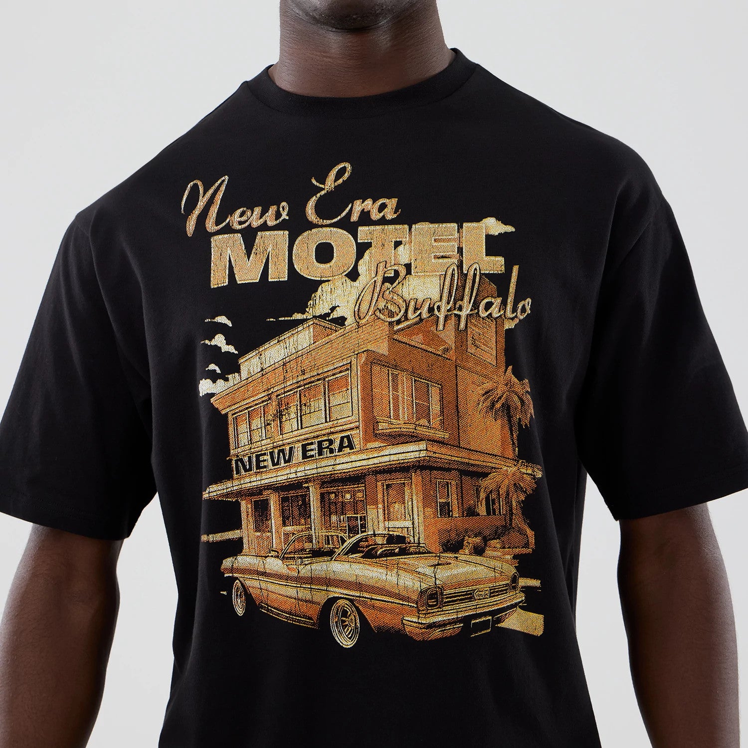 The model is wearing this New Era Motor Graphic Oversized T-Shirt in black. 4