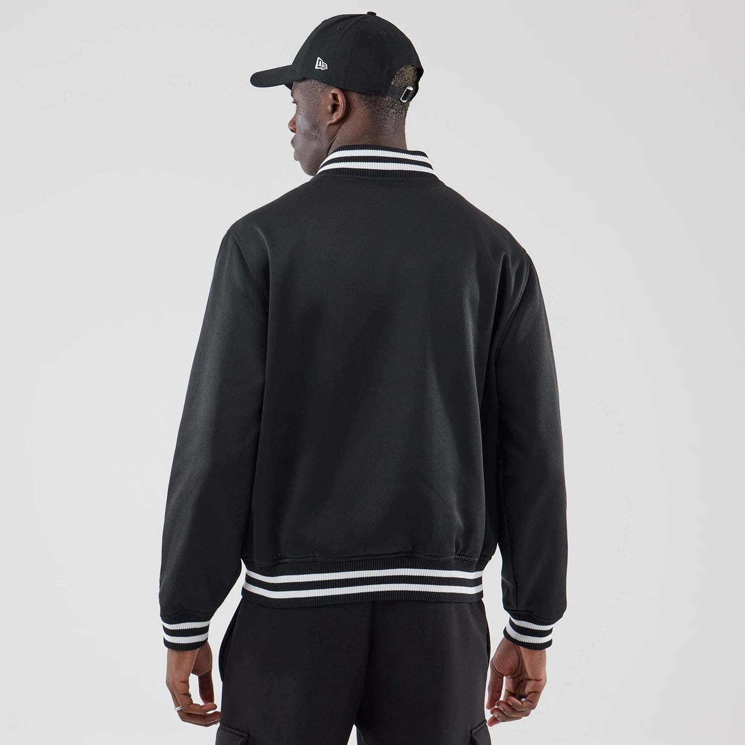 The model is wearing this New Era Jersey Bomber Jacket in black. 2