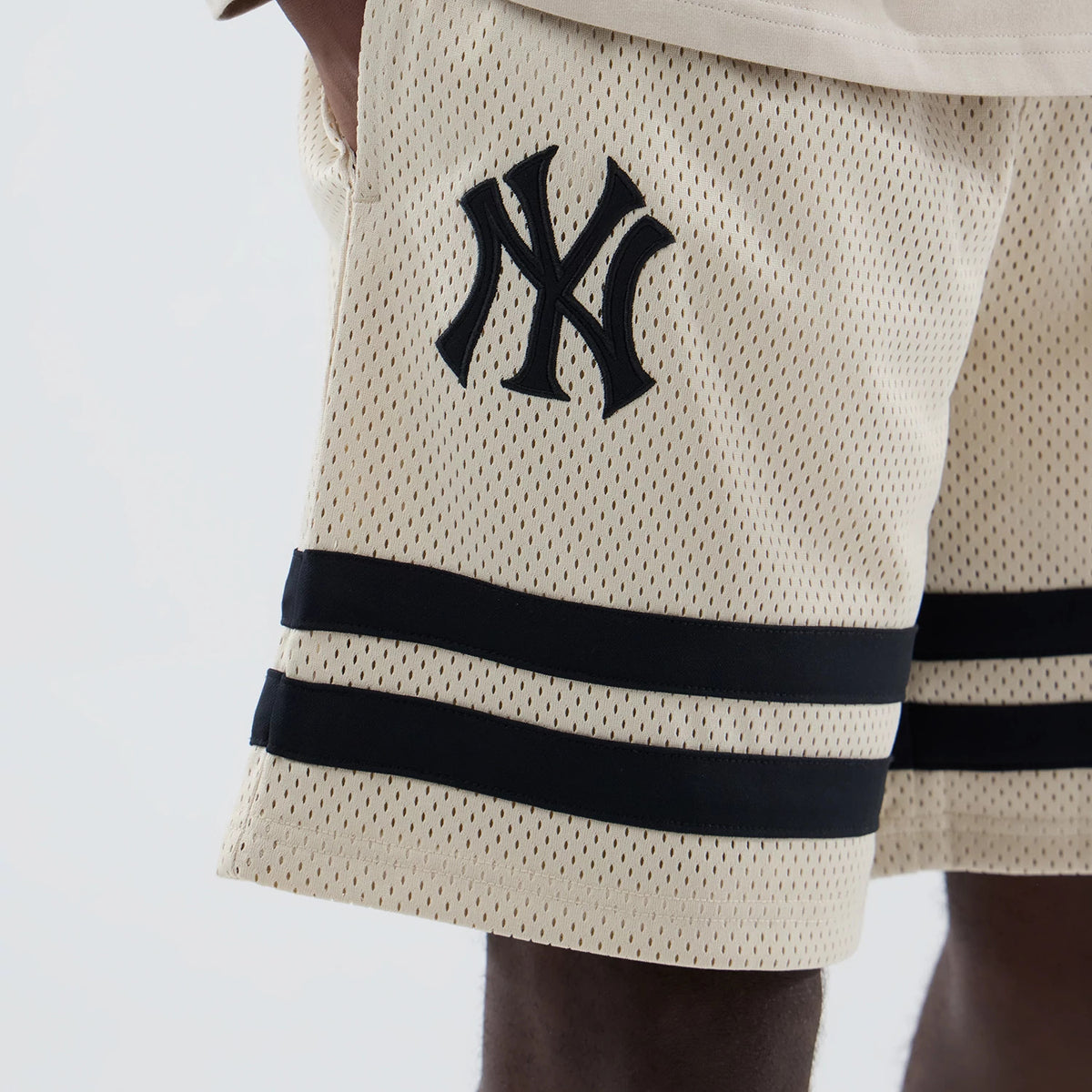 The model is wearing these MLB New York Yankees Oversized Mesh Shorts in light beige. 3