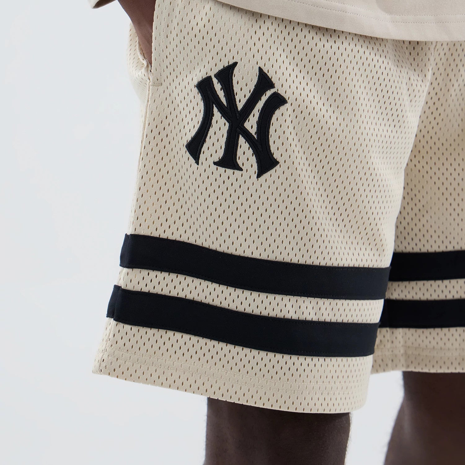 The model is wearing these MLB New York Yankees Oversized Mesh Shorts in light beige. 3