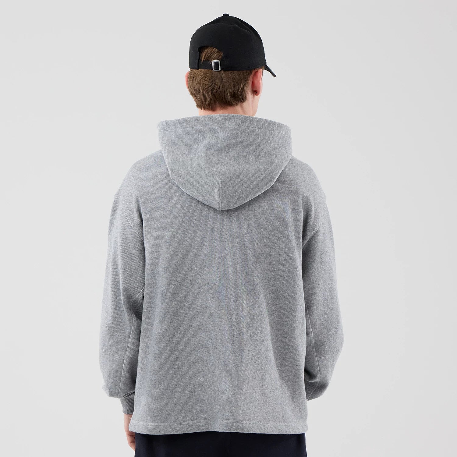 The model is wearing this New Era Open Hem Pullover Hoodie in grey. 2