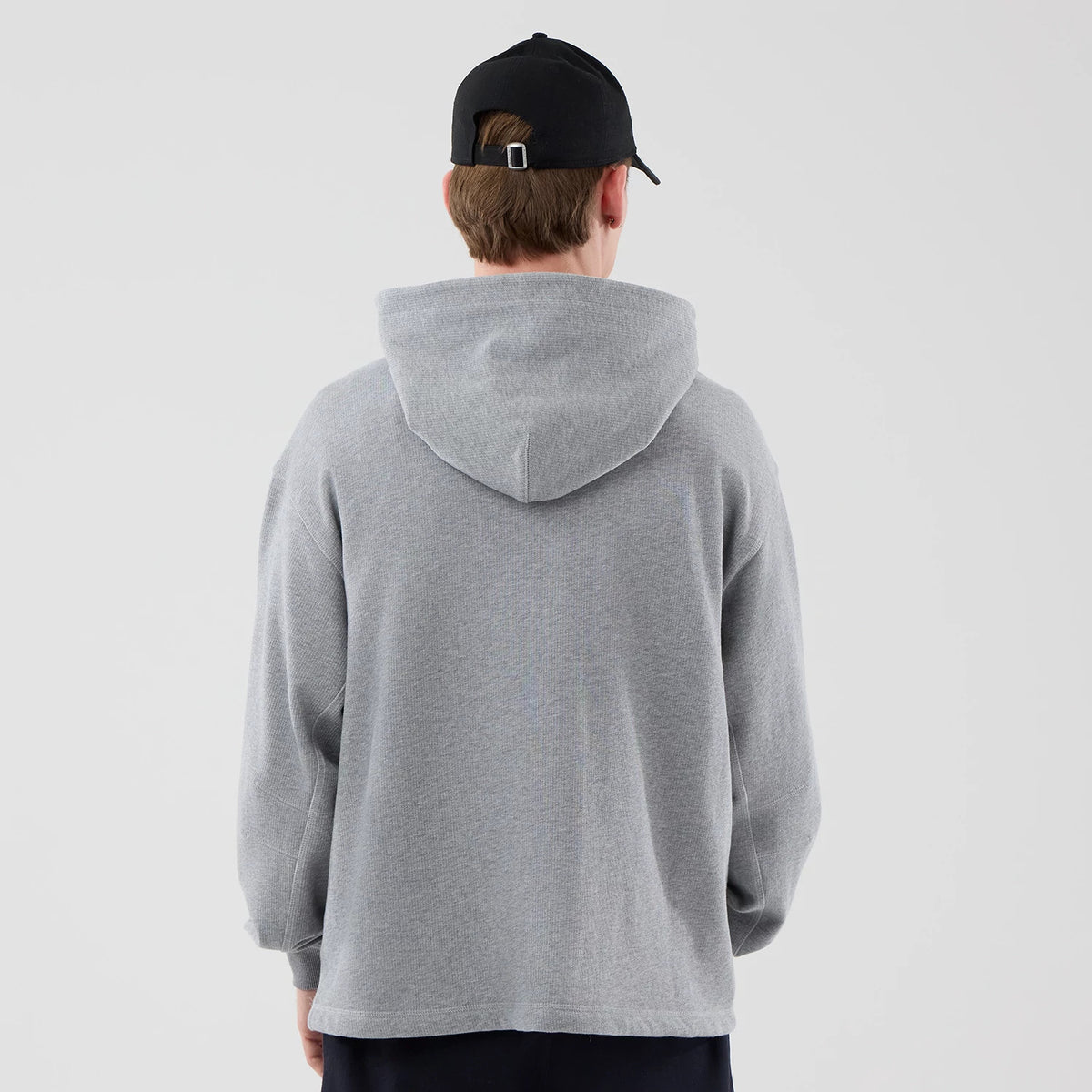 The model is wearing this New Era Open Hem Pullover Hoodie in grey. 2