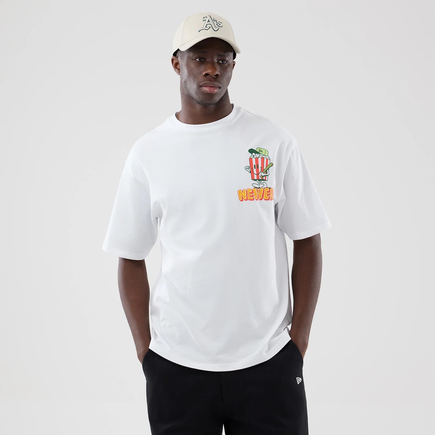 The model is wearing this New Era Baseball Popcorn Graphic Oversized T-Shirt in white. 3